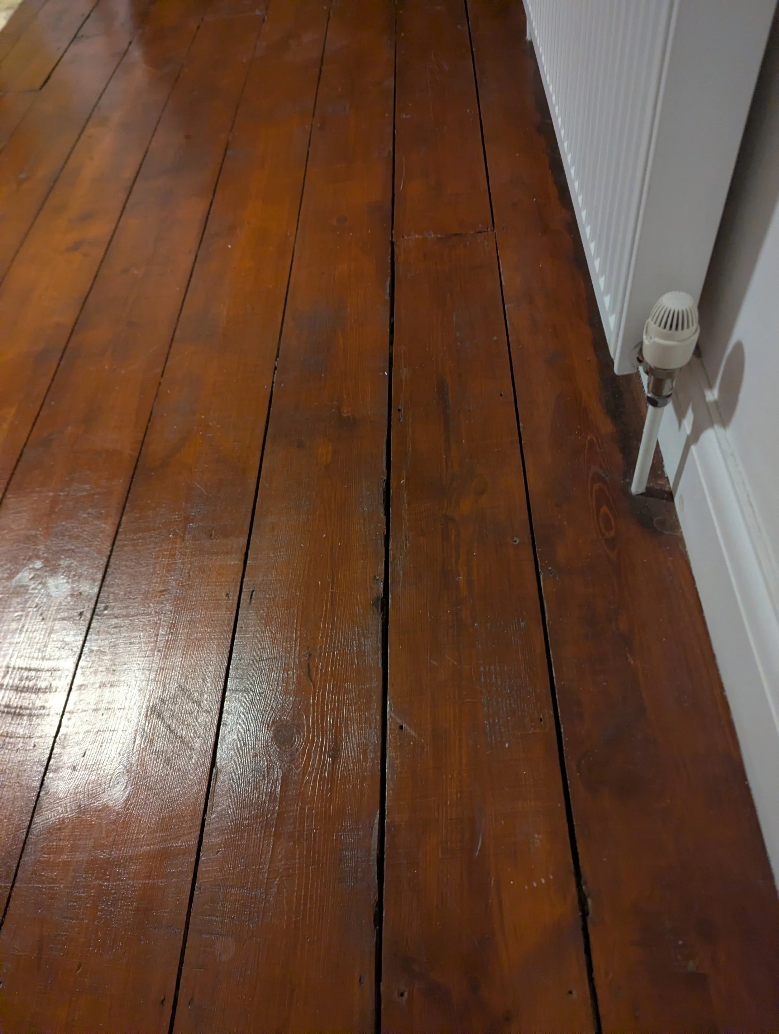 This shows a Georgian floorboard repaired and restored to look brand new. Chip repair, scratch repair, split repair, flooring repair.