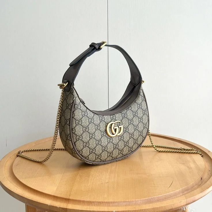 A Gucci shoulder bag with a chain strap, featuring the iconic GG pattern and gold GG logo.
