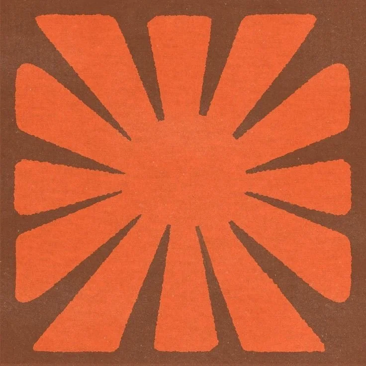 Orange and brown stylized flower design with elongated petals radiating from the center.