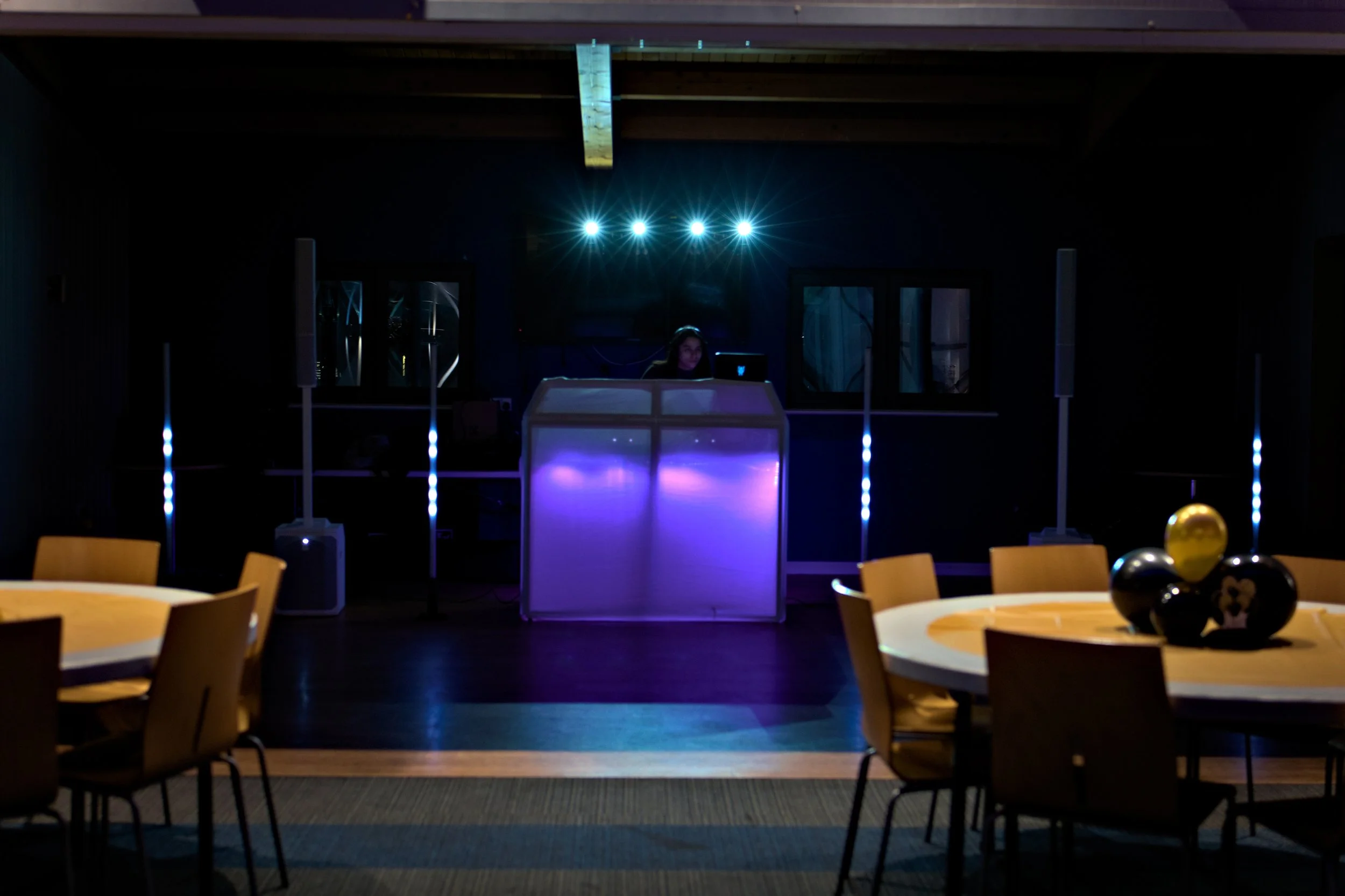 A DJ mixing console with illuminated controls in a dark setting.