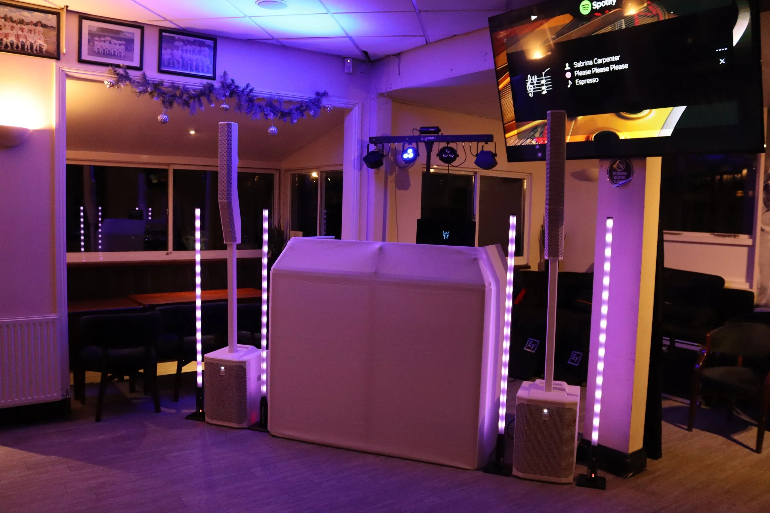 A DJ mixing console with illuminated controls in a dark setting.