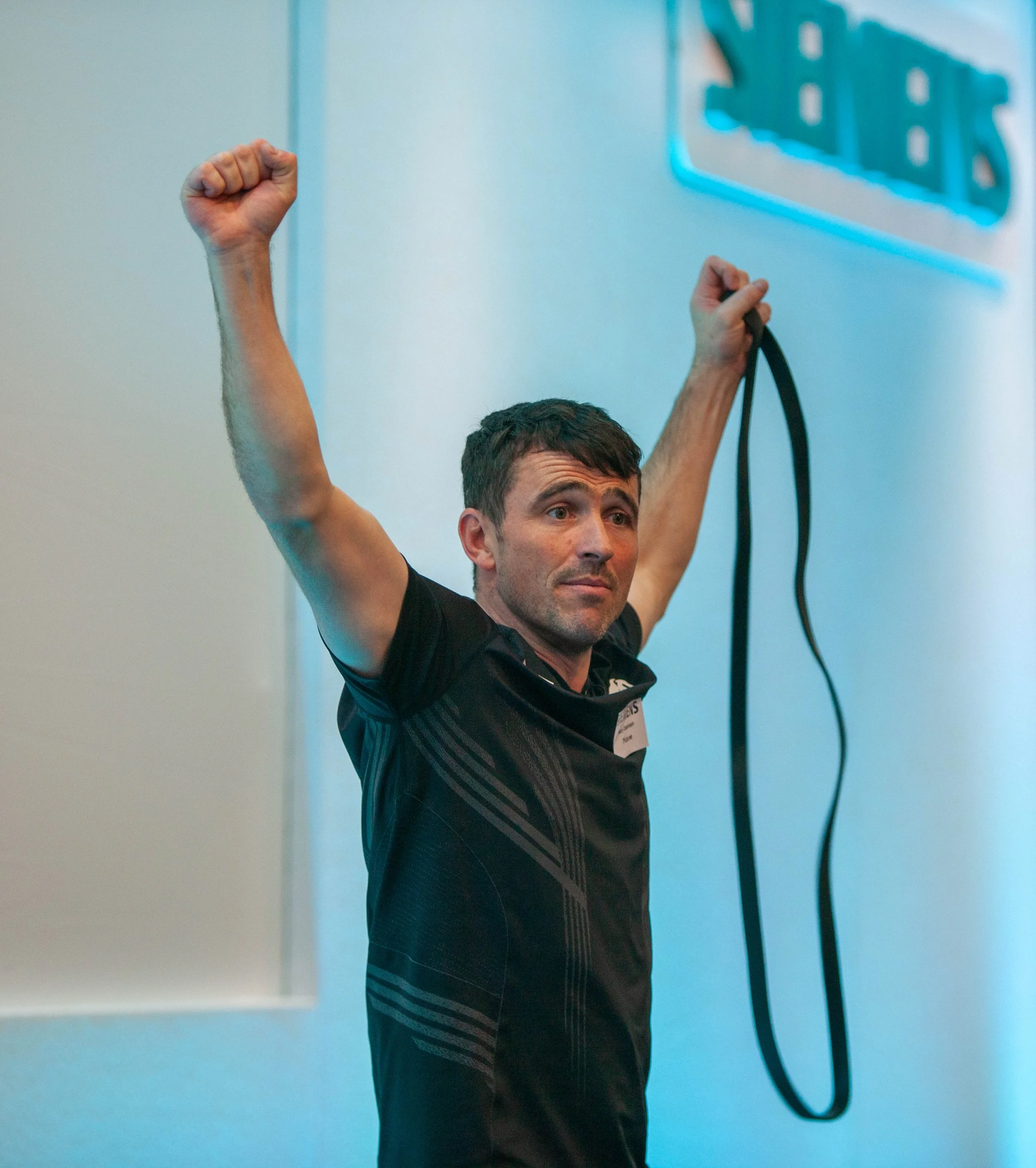 A man stretching with a resistance band in a gym.