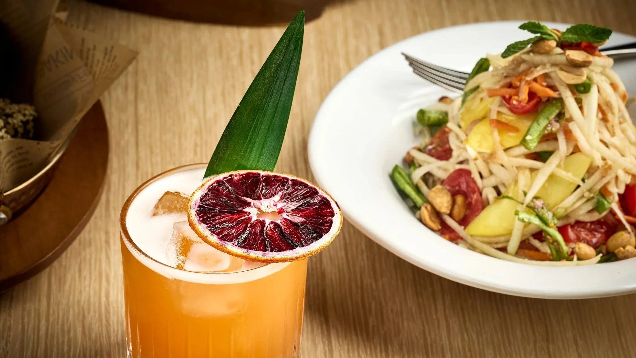 Fresh Thai papaya salad paired with a citrus-based drink, capturing the balance of sweet, sour, and spicy flavors in LA Very Thai Westfield Century City.