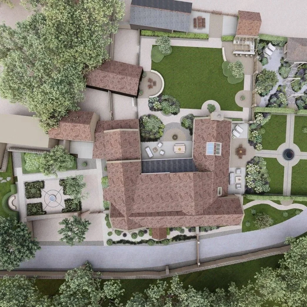 Aerial view of a backyard with a large lawn, garden beds, paved walkways, a patio with outdoor furniture, and surrounding trees and landscaped areas.