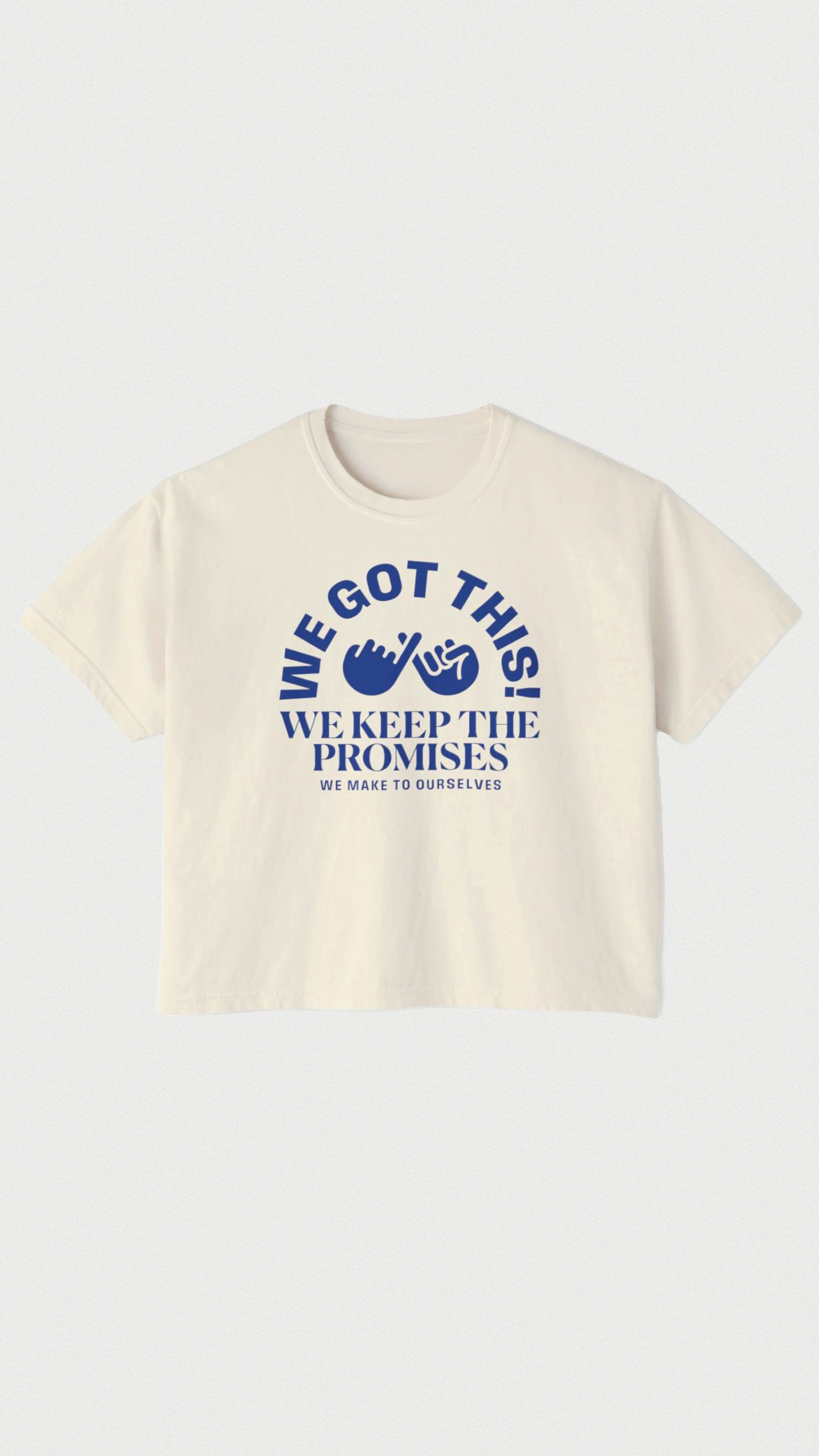 White T-shirt with blue text that says, "WE GOT THIS! WE KEEP THE PROMISES WE MAKE TO OURSELVES." with a stylized hand and check mark logo.