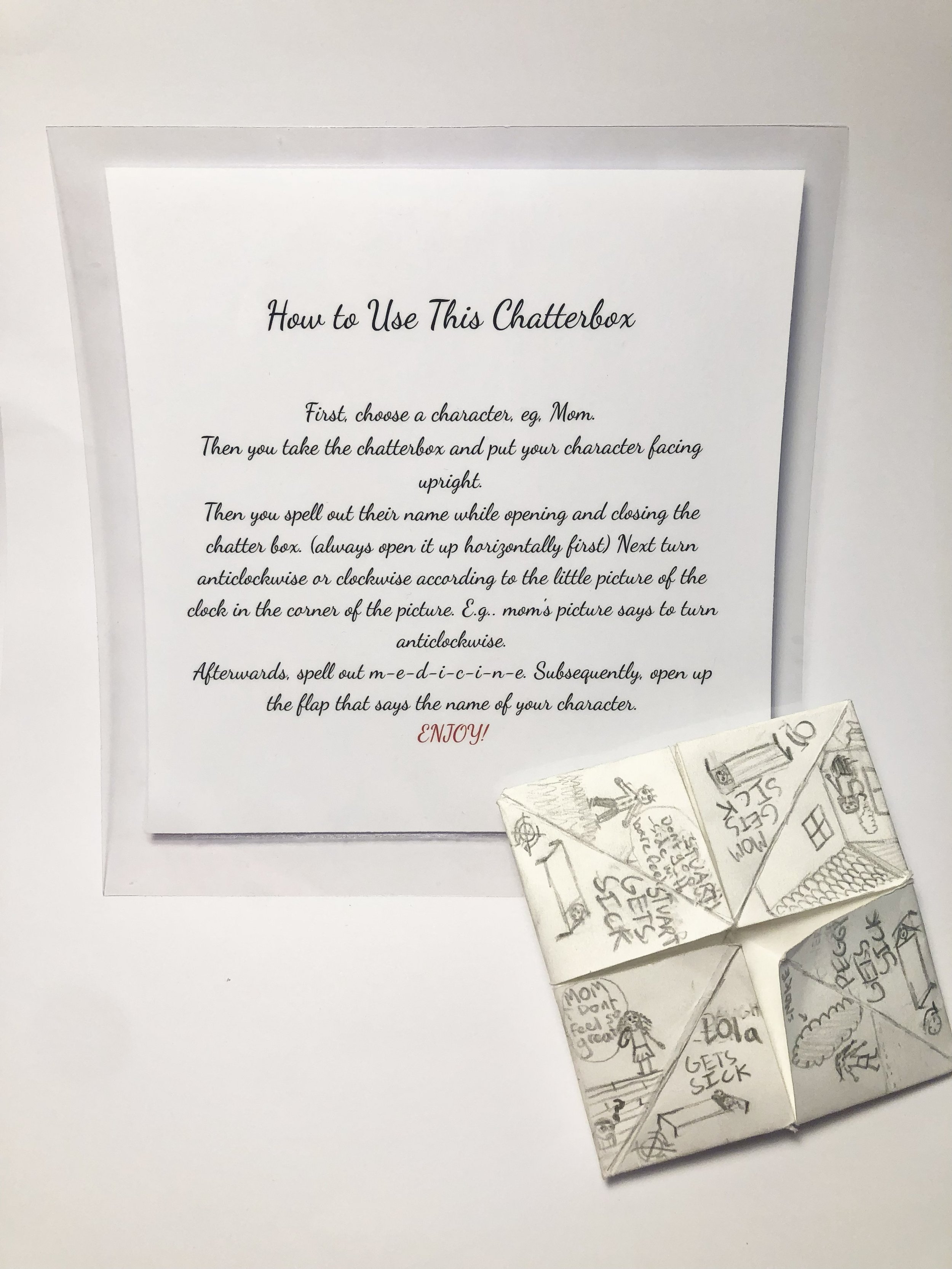 A printed sheet with instructions on how to use a chatterbox, placed on a white background. The chatterbox, decorated with sketches and words, is positioned underneath the sheet.