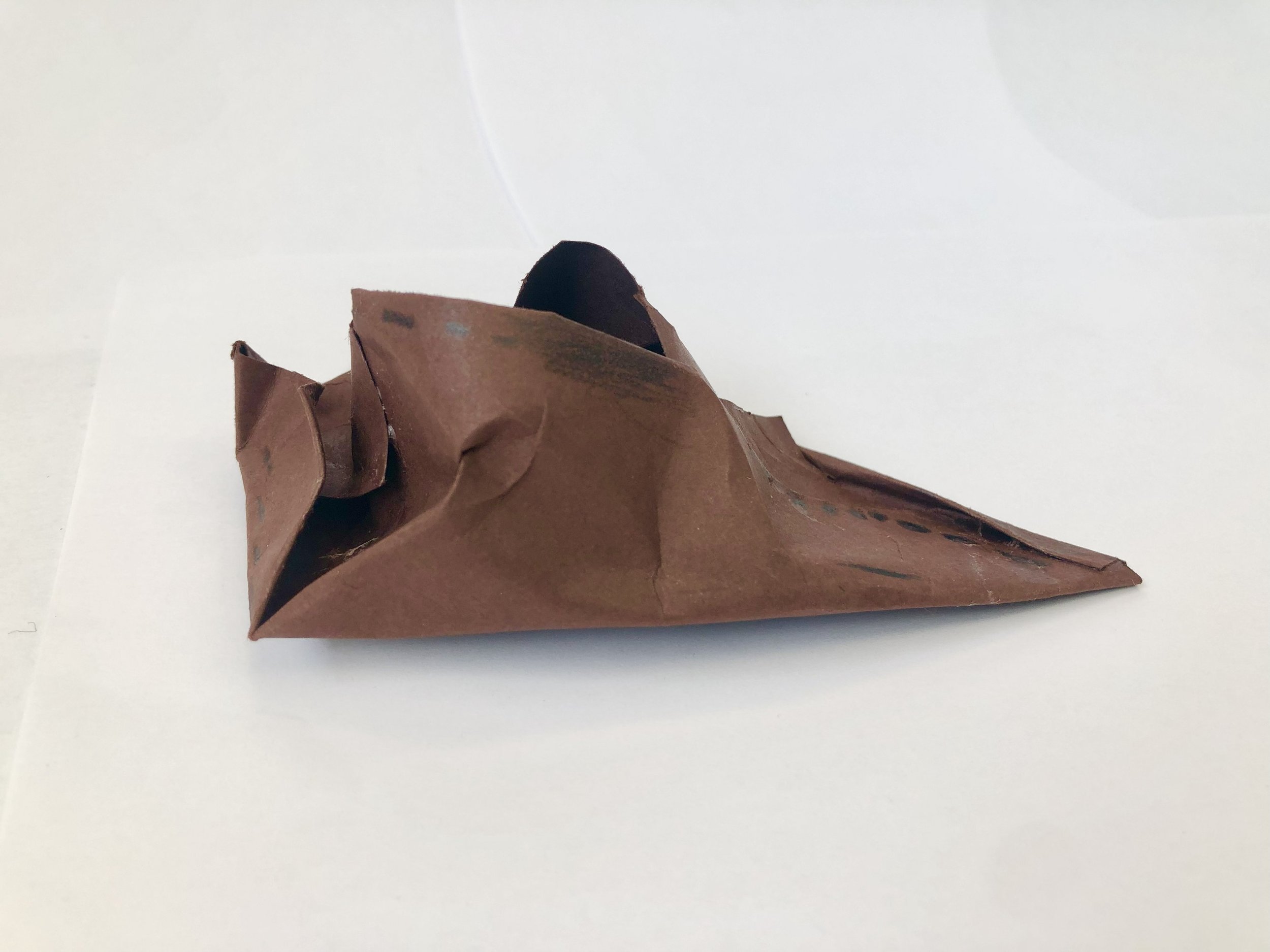 Crumpled brown paper on a white surface.