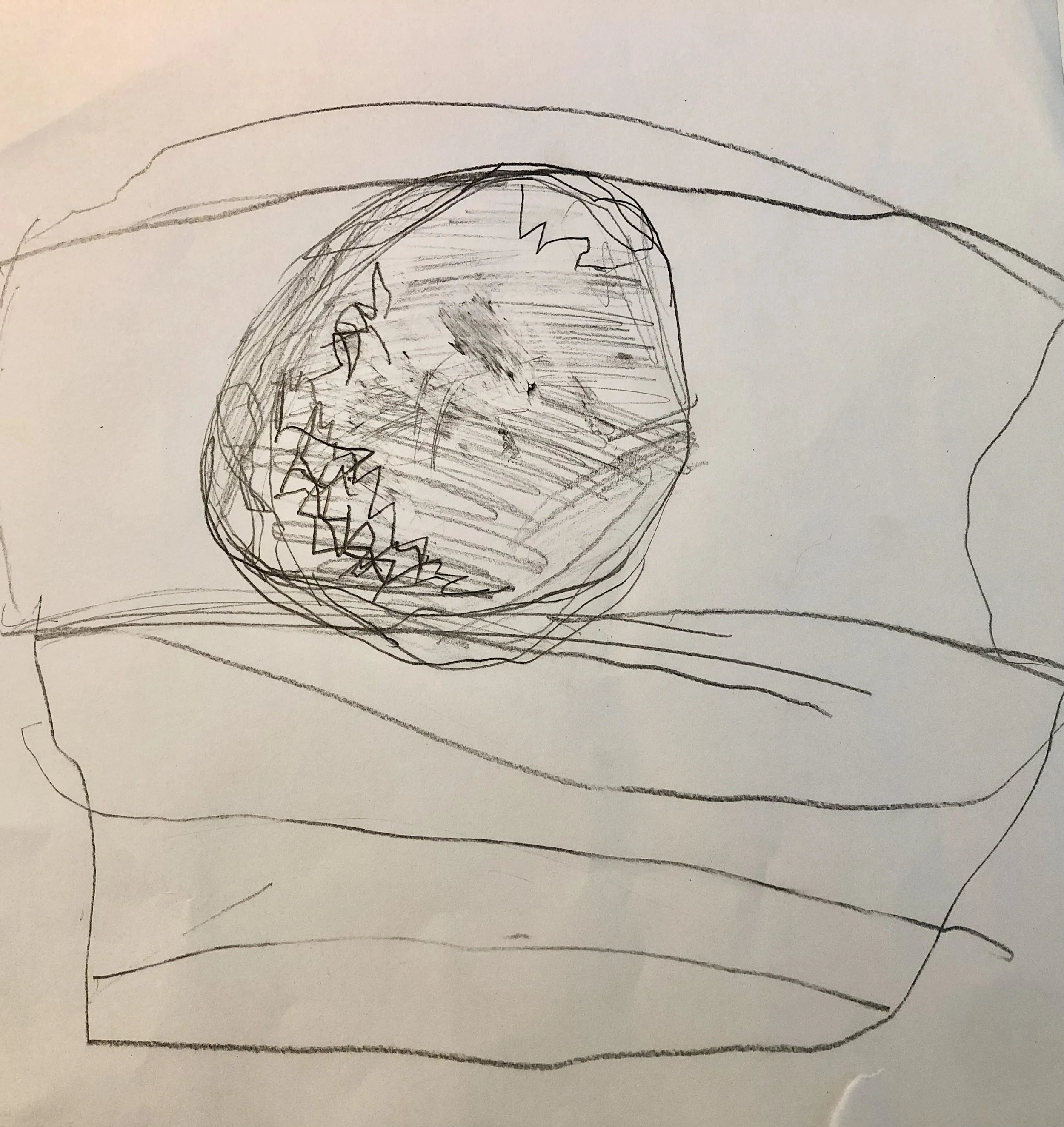 Child's rough pencil drawing of a round plate with a food item, possibly a burger, on a plate with lines indicating a plate and a napkin.