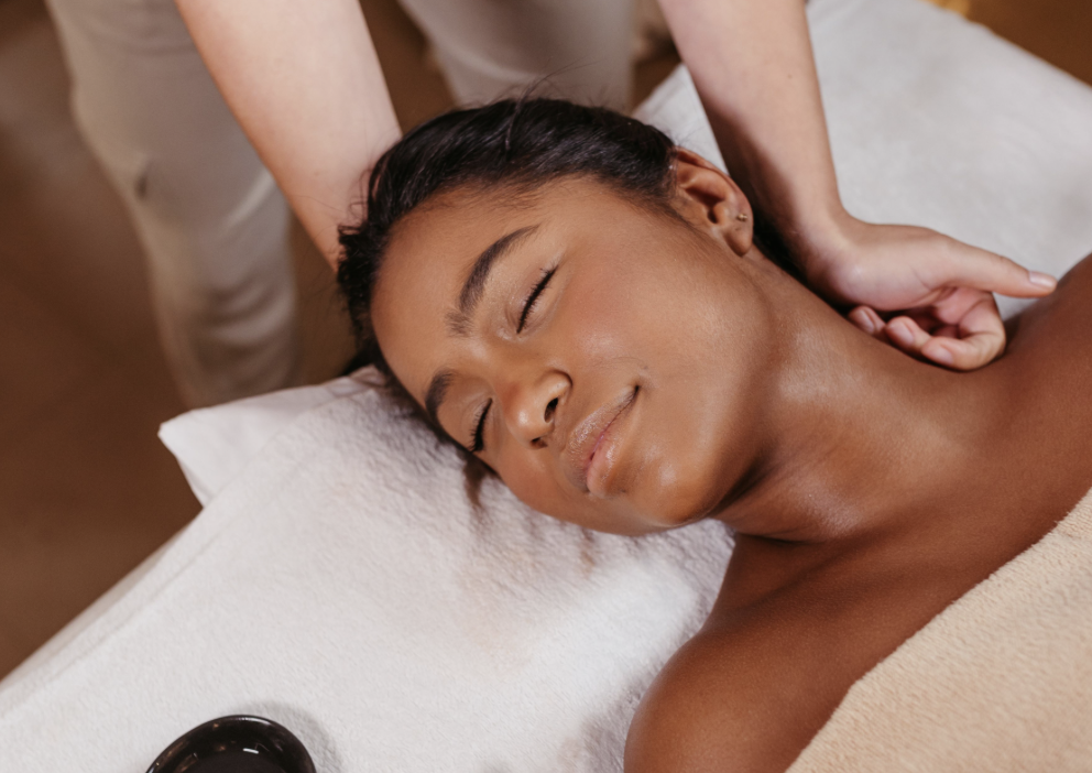 Woman receiving a relaxing massage on her neck and shoulders in a spa setting.