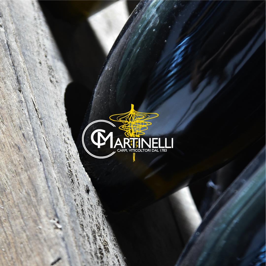 Bottiglia di vino posizionata su un tavolo di legno, con un'etichetta che recita "Martinelli - Carpi, viticoltori dal 1783".