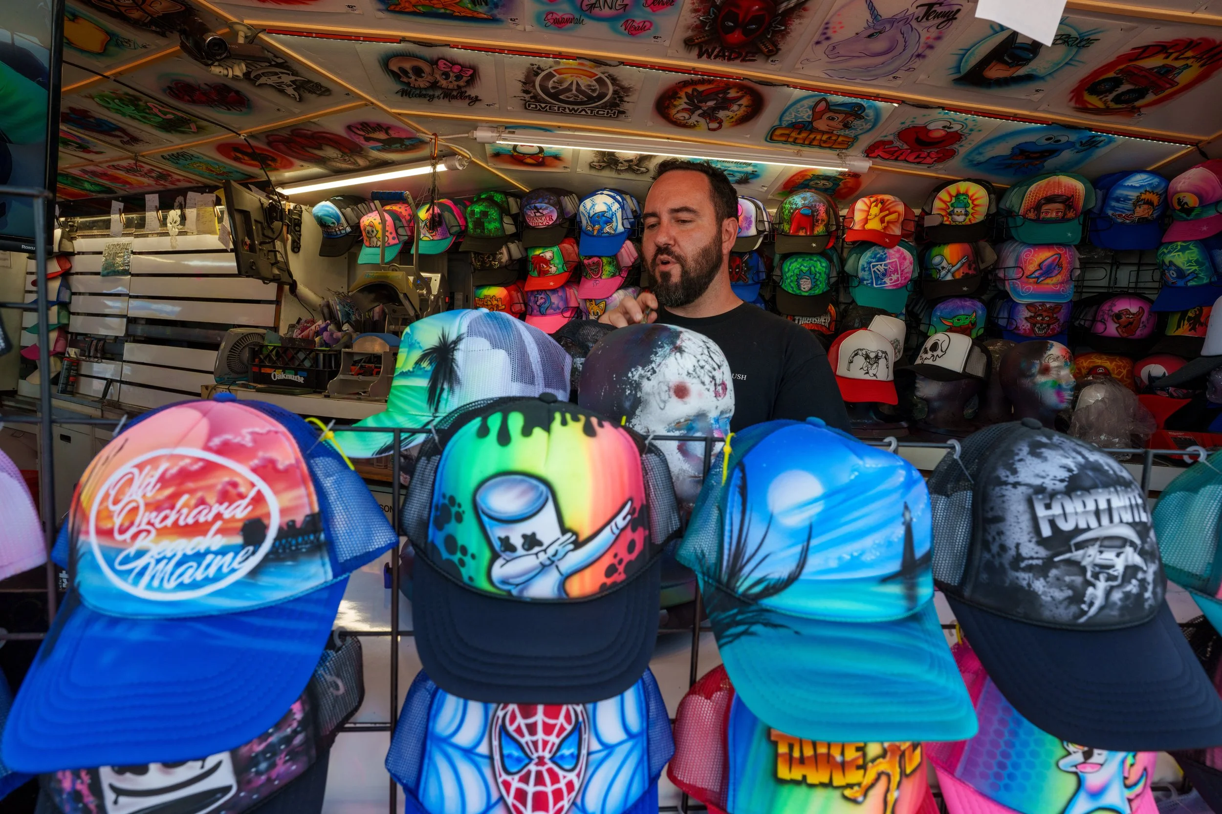 Old Orchard Beach Airbrush Owner custom painting orders as customers watch the process live