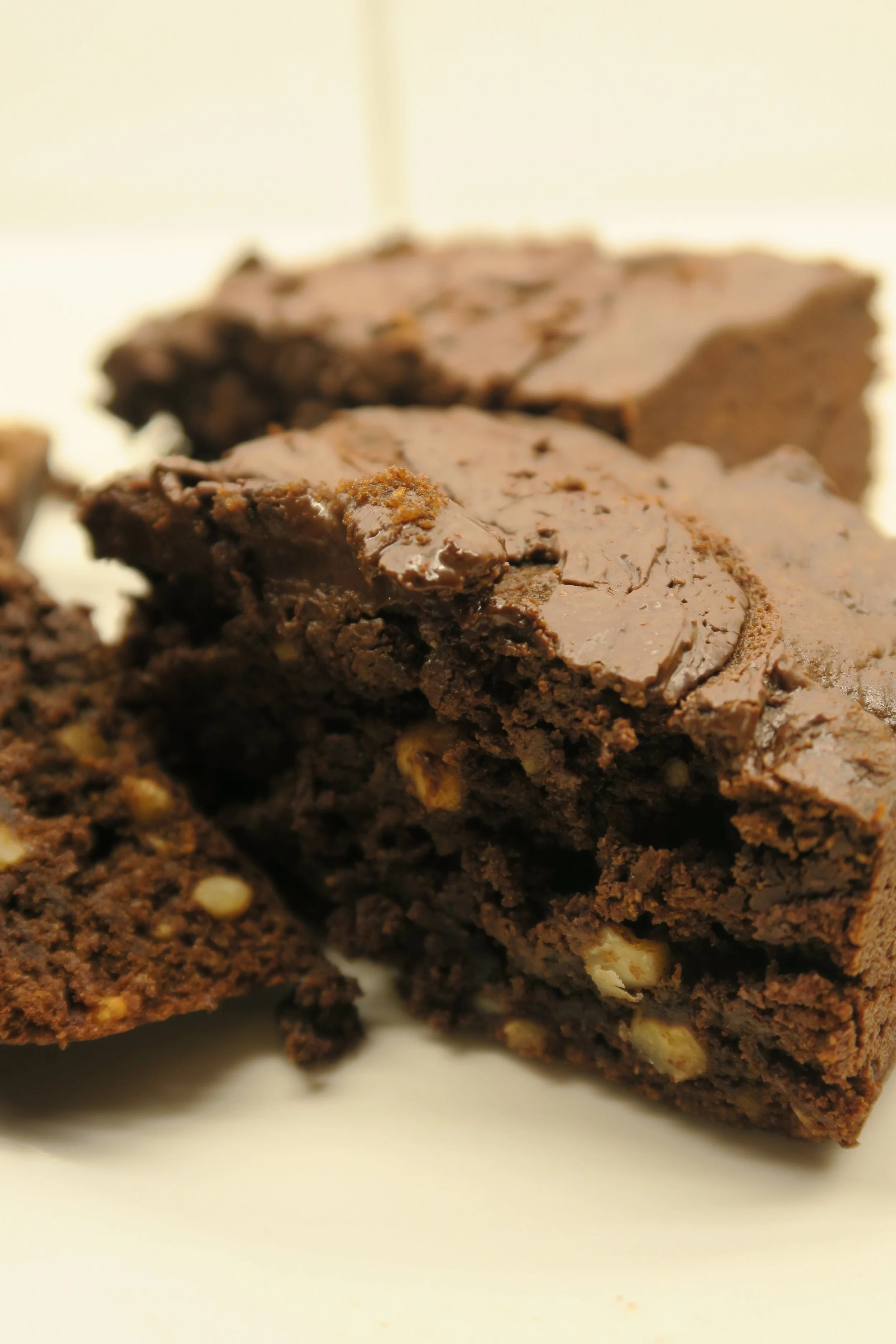 Close-up of a chocolate brownie with nuts, showing a moist and dense texture.