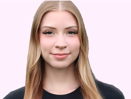 Young woman with long blonde hair winking, wearing a black top against a light background.
