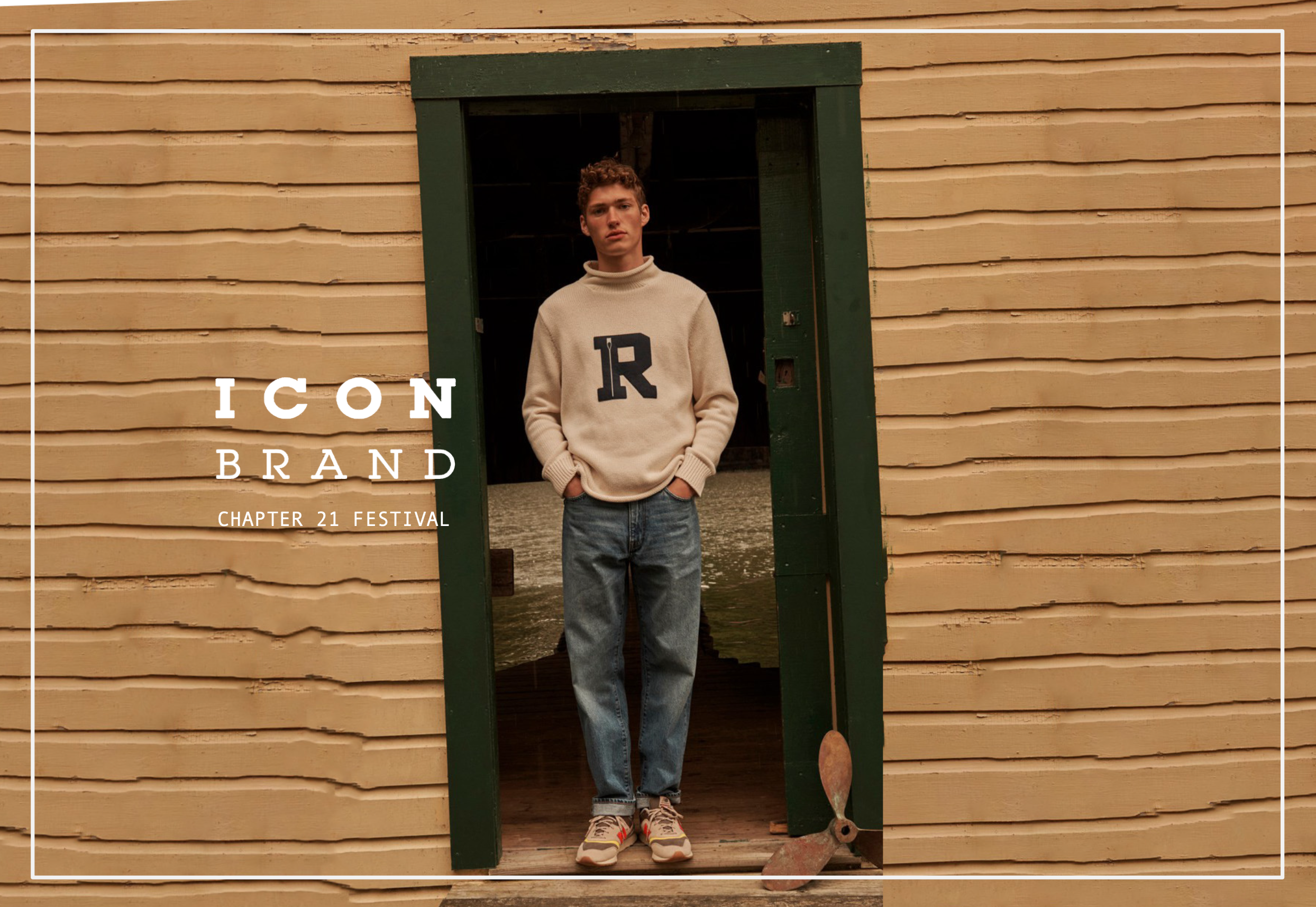 A young man standing in a doorway of a tan wooden building, wearing a cream sweater with a large letter 'R' on it, blue jeans, and sneakers, with some water visible inside the building. The text 'ICON BRAND CHAPTER 21 FESTIVAL' is overlaid on the left side of the image.