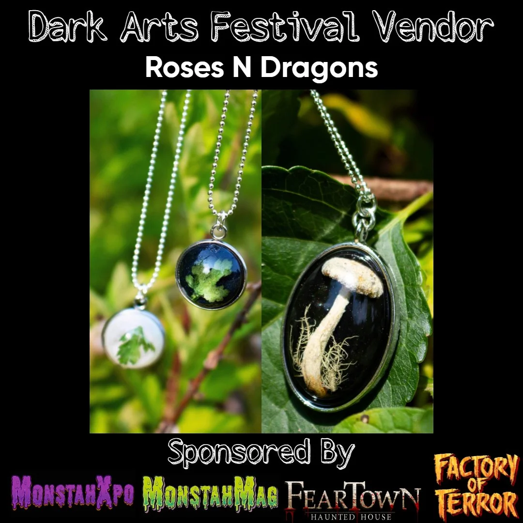 Event poster for Dark Arts Festival Vendor featuring jewelry with nature-themed pendants, including a leaf and a mushroom design, displayed against green foliage.