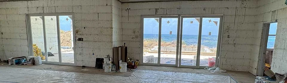 View of the Living Room at Turtle Bluff during construction with the verandah pool and Caribbean Sea in the back yard