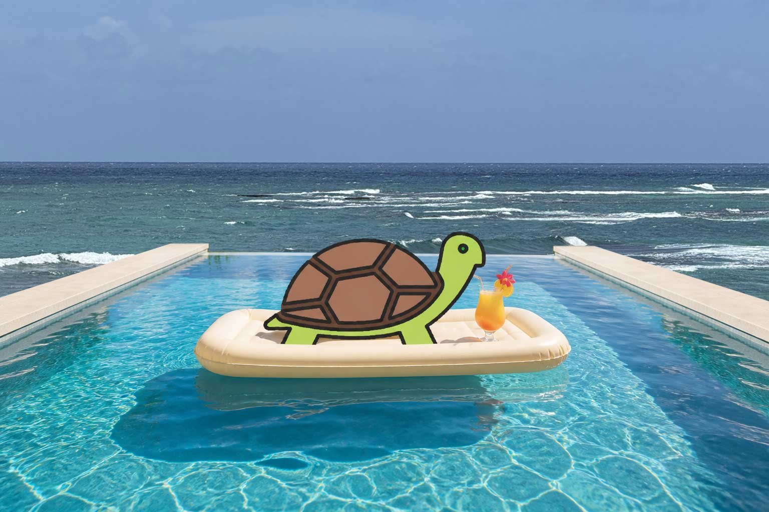 Infinity edge pool with the Caribbean Sea in the background. In the pool, a Turtle on a float with a tropical drink.