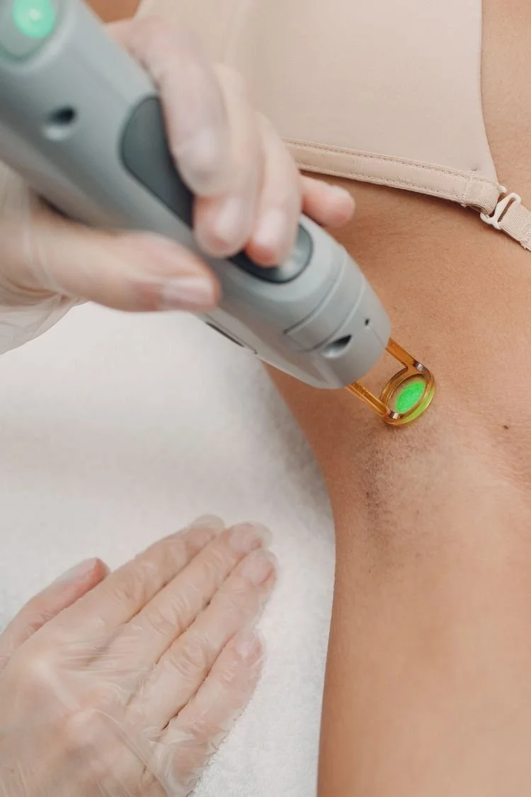 A person undergoing a laser hair removal procedure on their leg in a clinical setting.