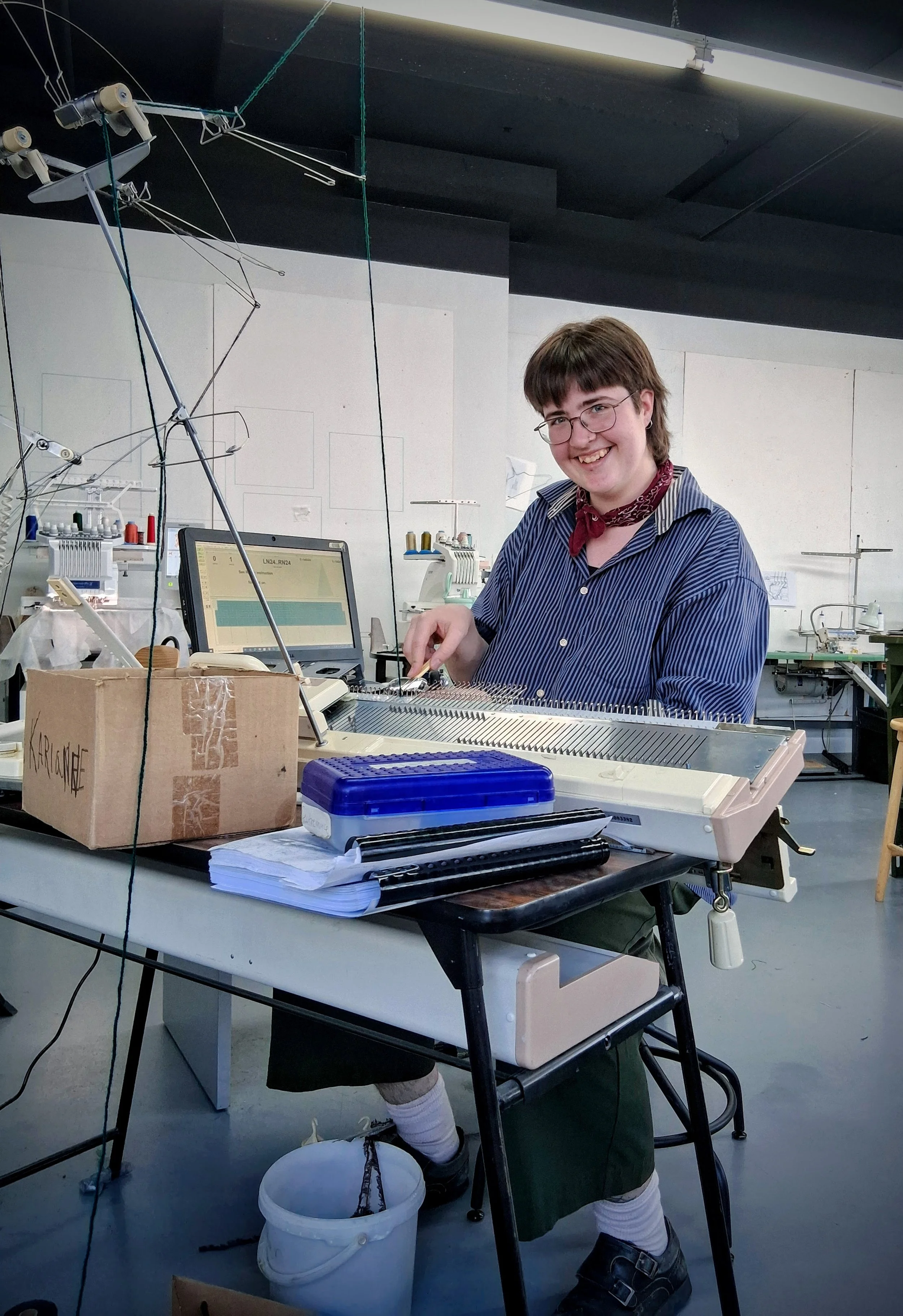 Camobre travaillant au Centre des textiles contemporains de Montréal, avec sa machine à tricoter.