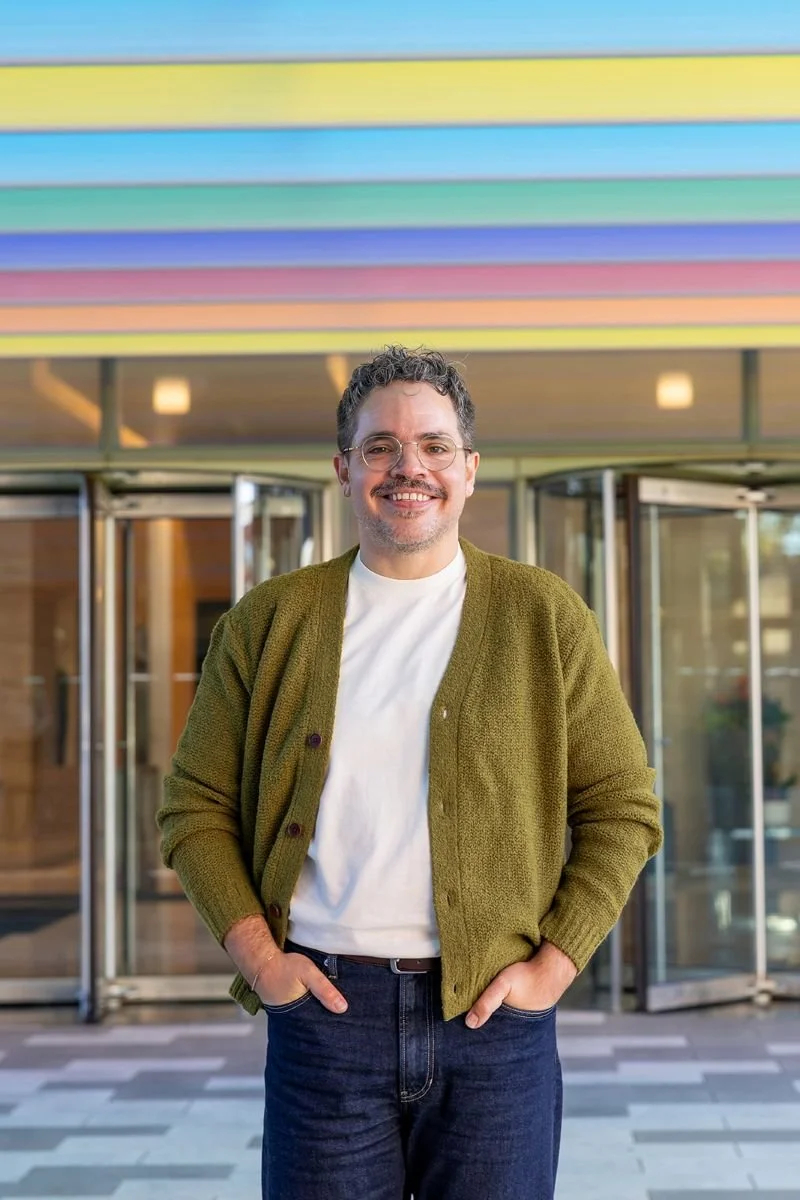 Braden (therapist) standing in front of building with rainbow lights.