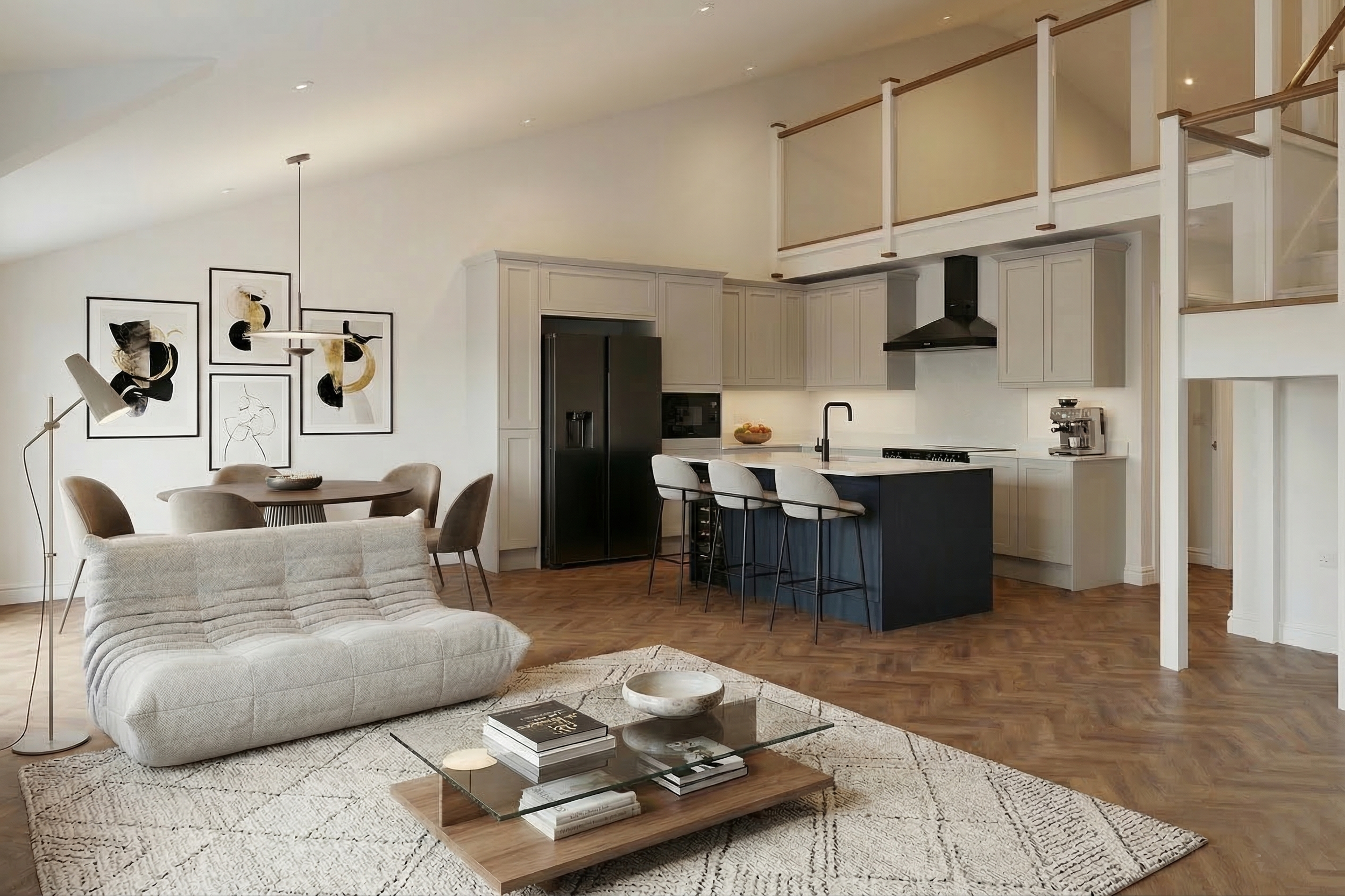 Open-concept living room and kitchen with white walls, wooden flooring, modern furniture, wall art, and a loft area.