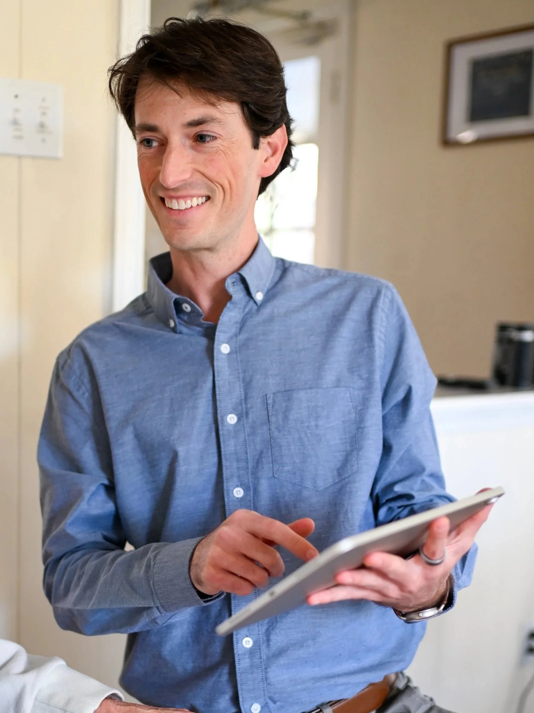 A StillPoint Balance & Dizziness vestibular therapist holding an iPad during an in-home visit in Austin, TX