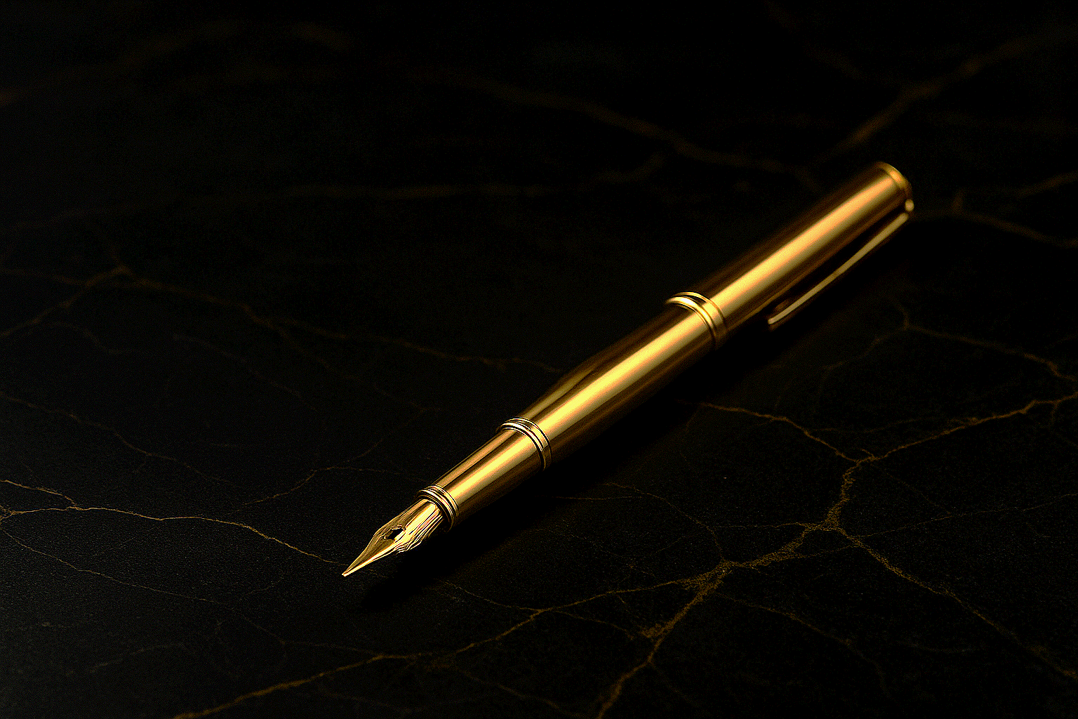 A gold-colored fountain pen placed on a black textured surface.