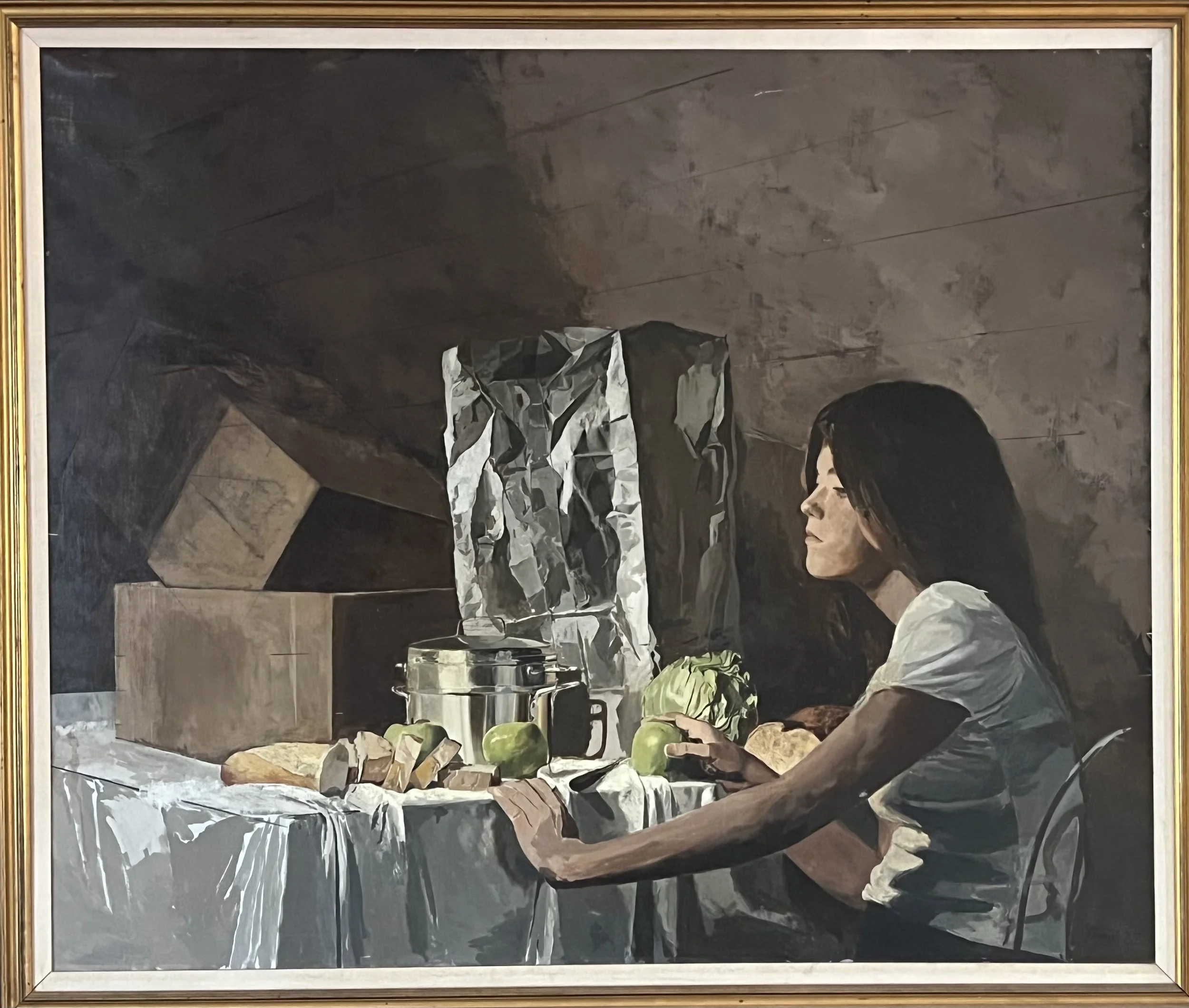Thomas Yerxa painting of a woman with long black hair sitting at a table with a white cloth, surrounded by food items and kitchen appliances, in a dimly lit room with a rocky wall background.