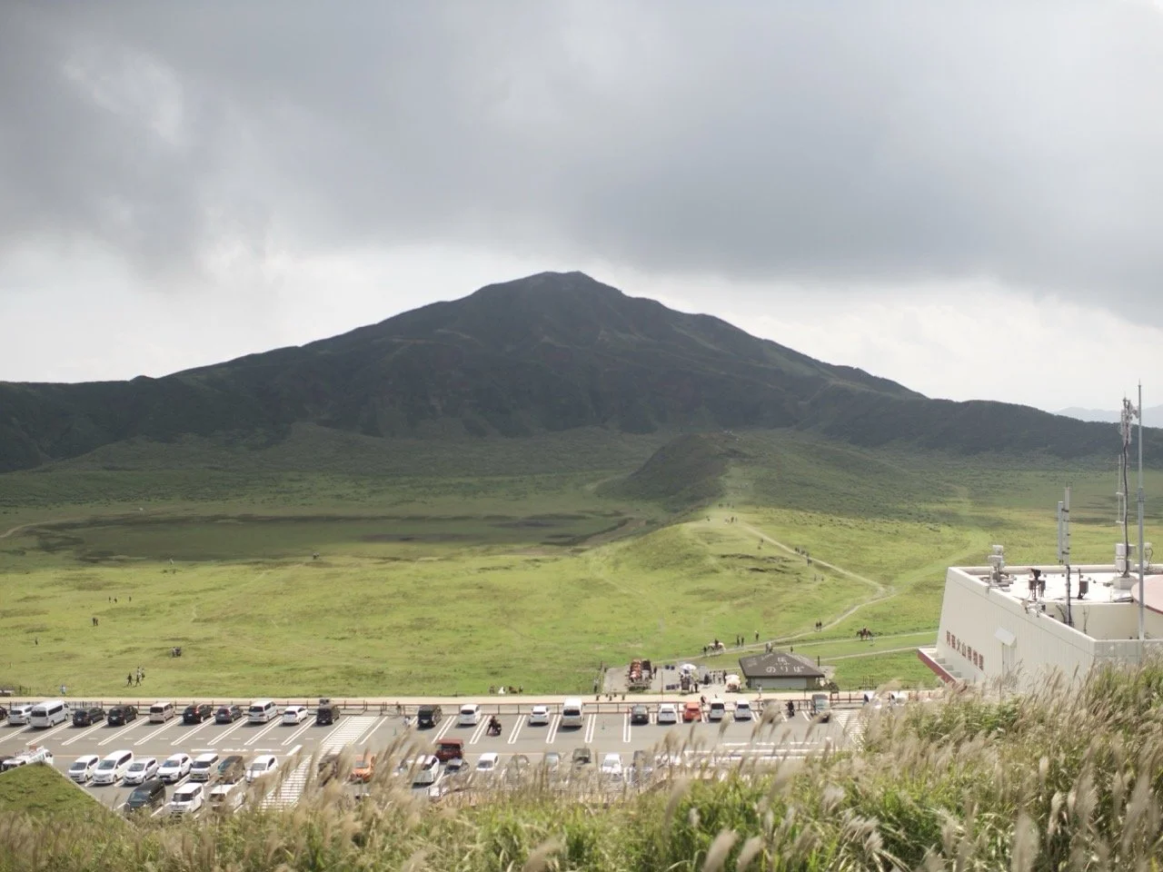 Grey clouds meet verdant caldera mountains in the middle of the massive crater that makes up Mt. Aso in the center of the island of Kyushu.