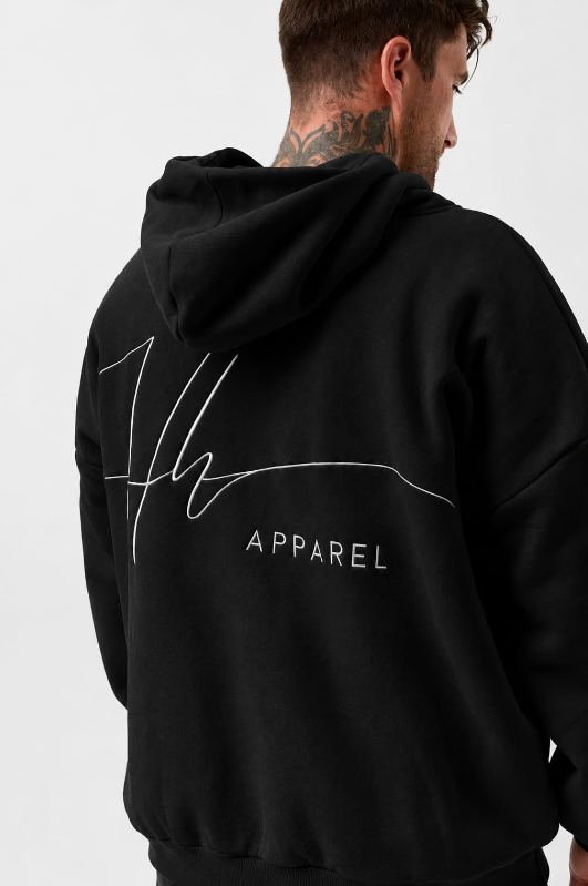 Back view of a man wearing a black hoodie with white embroidered text that says "Hoodie Hoo Apparel".