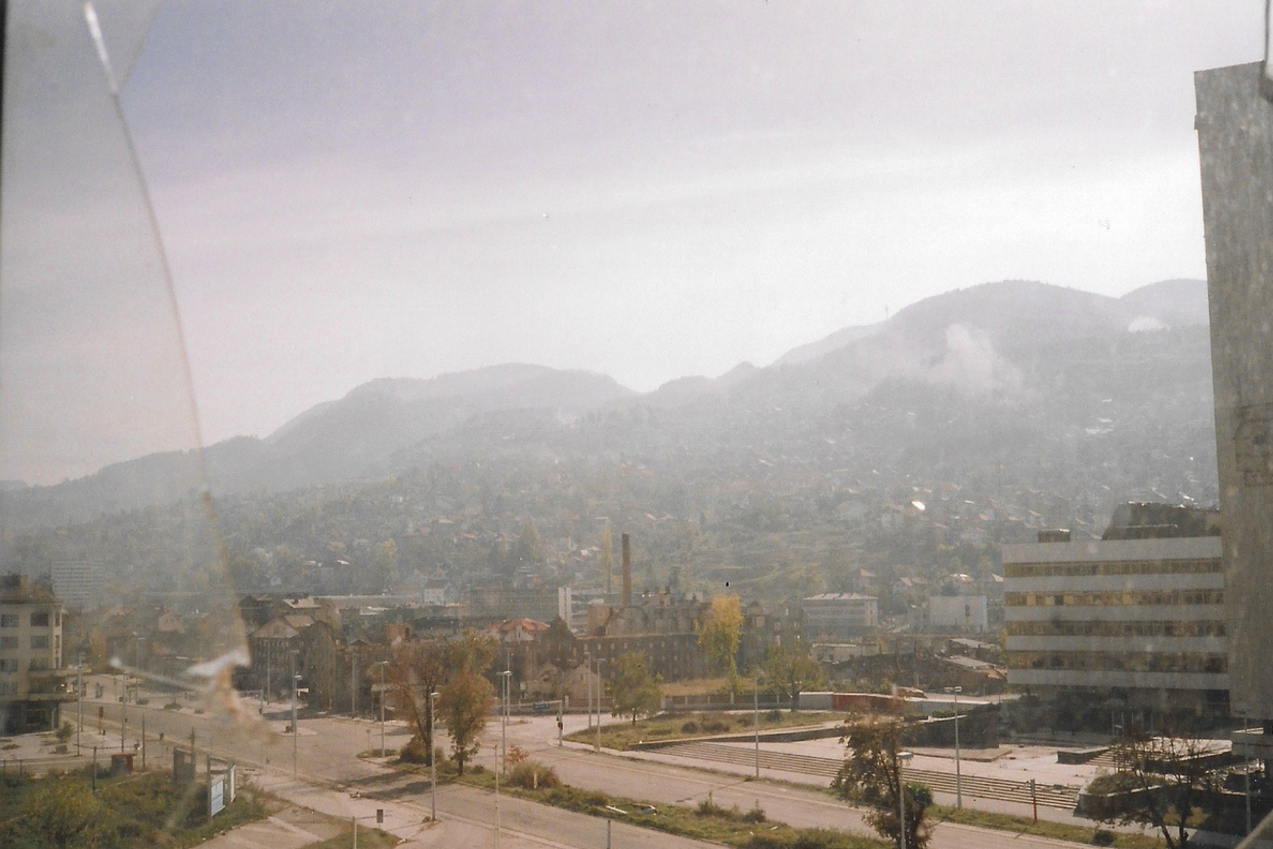 A picture of war-torn Sarajevo, Bosnia in 1993 through a window with broken glass