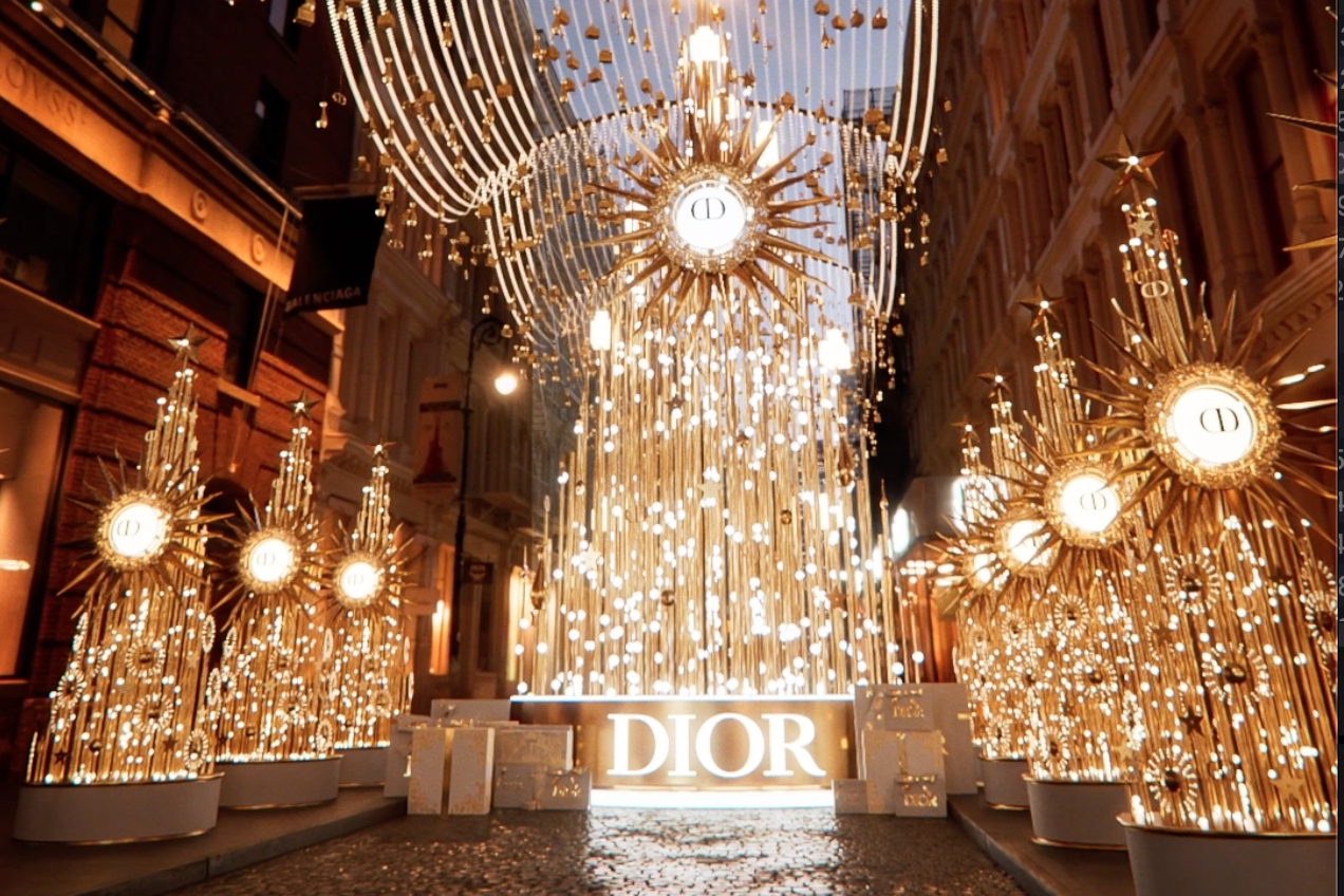 Luxurious Dior display with golden starburst decorations and illuminated Dior sign on a city street at night.