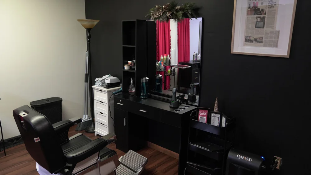 Barber station with a black chair and mirror