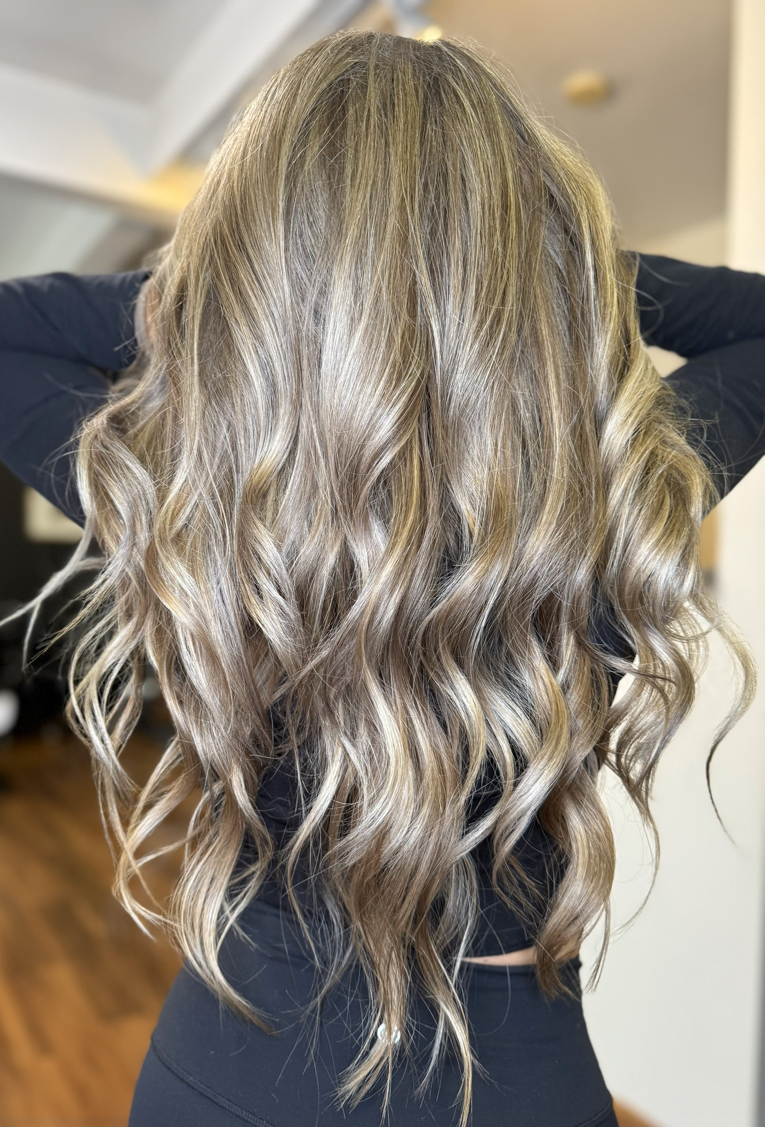 Back view of a woman with long, wavy, blonde hair.