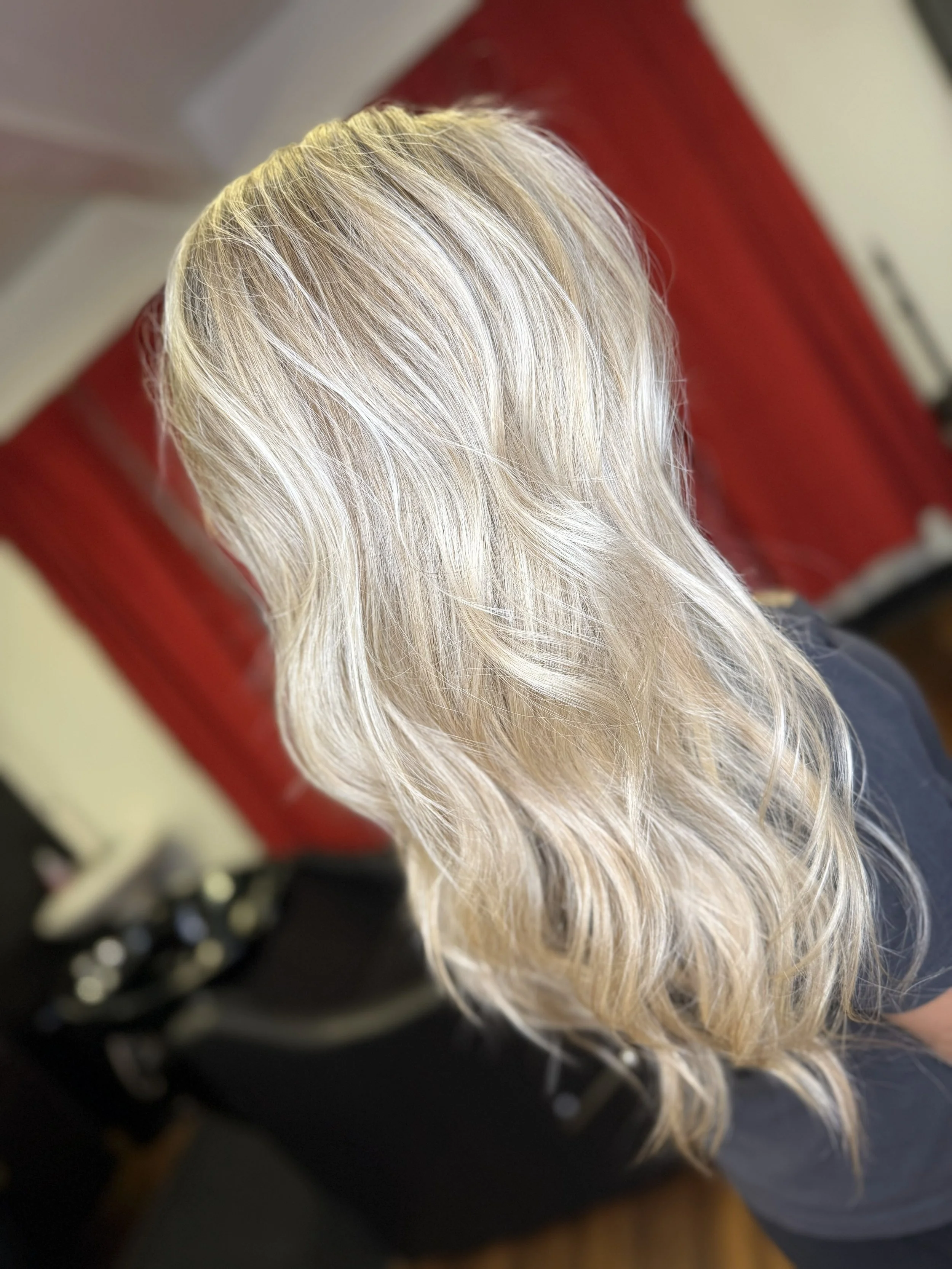Back view of a woman with long, wavy, blonde hair.