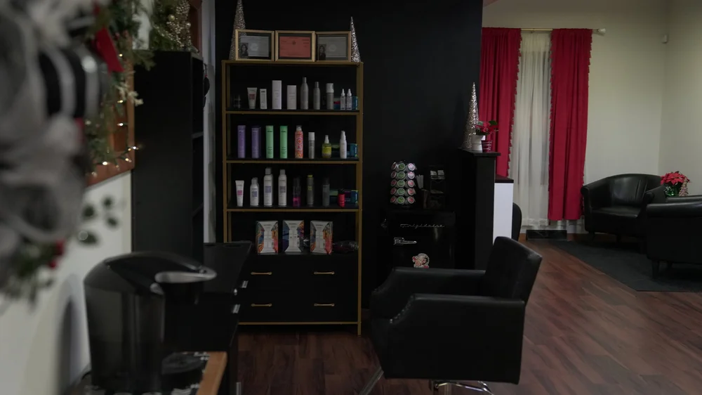 The Parlour's waiting area with red velvet curtains and black leather chairs