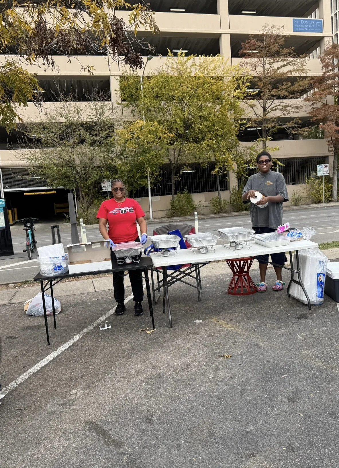 Scenic landscape of mountains surrounding a lake with grassy hills in the foreground and cloudy sky overhead.