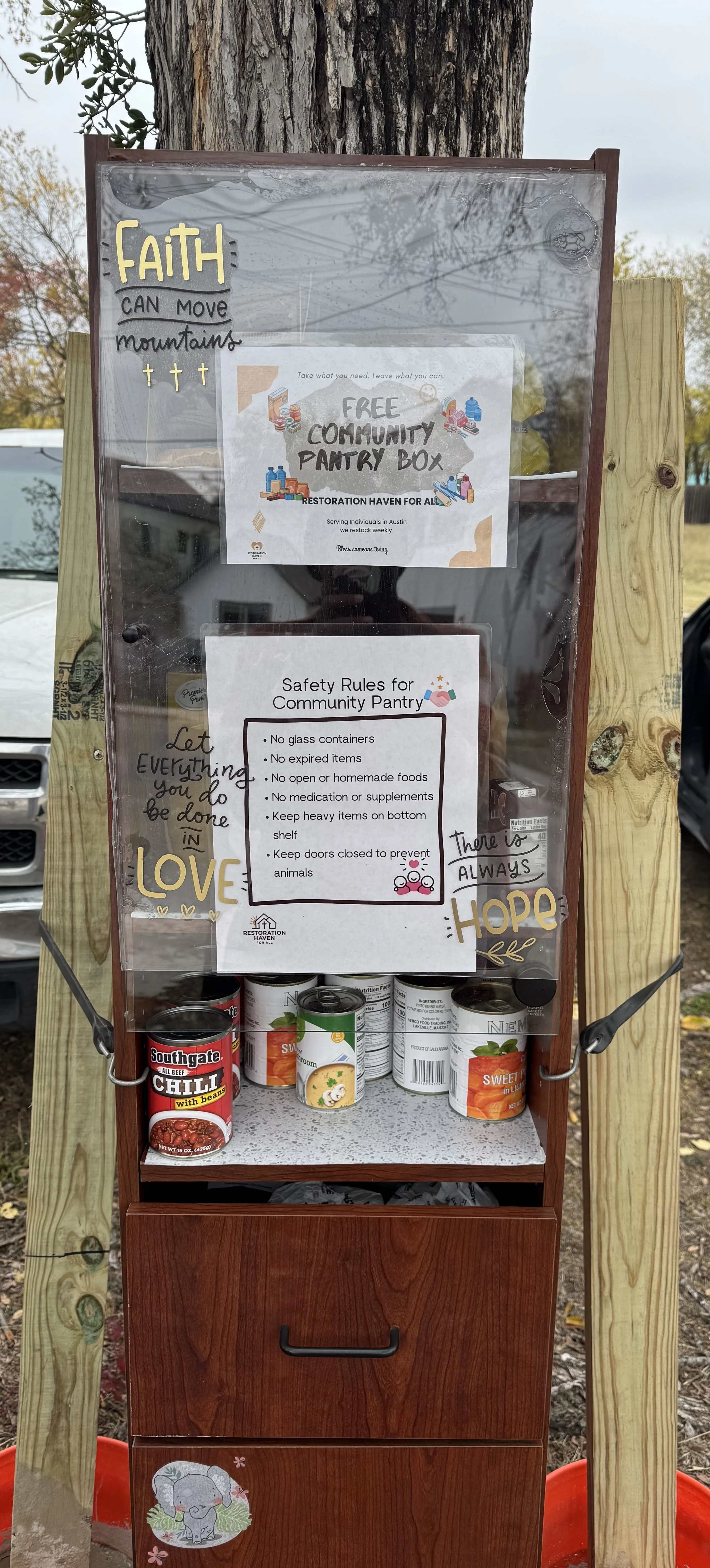 A landscape with snow-capped mountains in the distance, rolling hills in the foreground, and a modern building on the hillside.