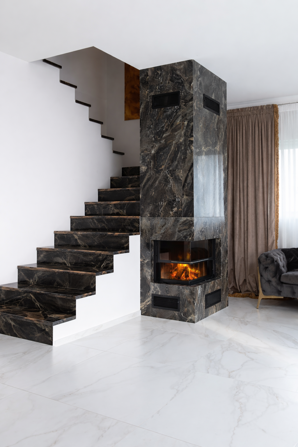 Modern interior with black marble staircase and fireplace, beige curtains, and a gray armchair.