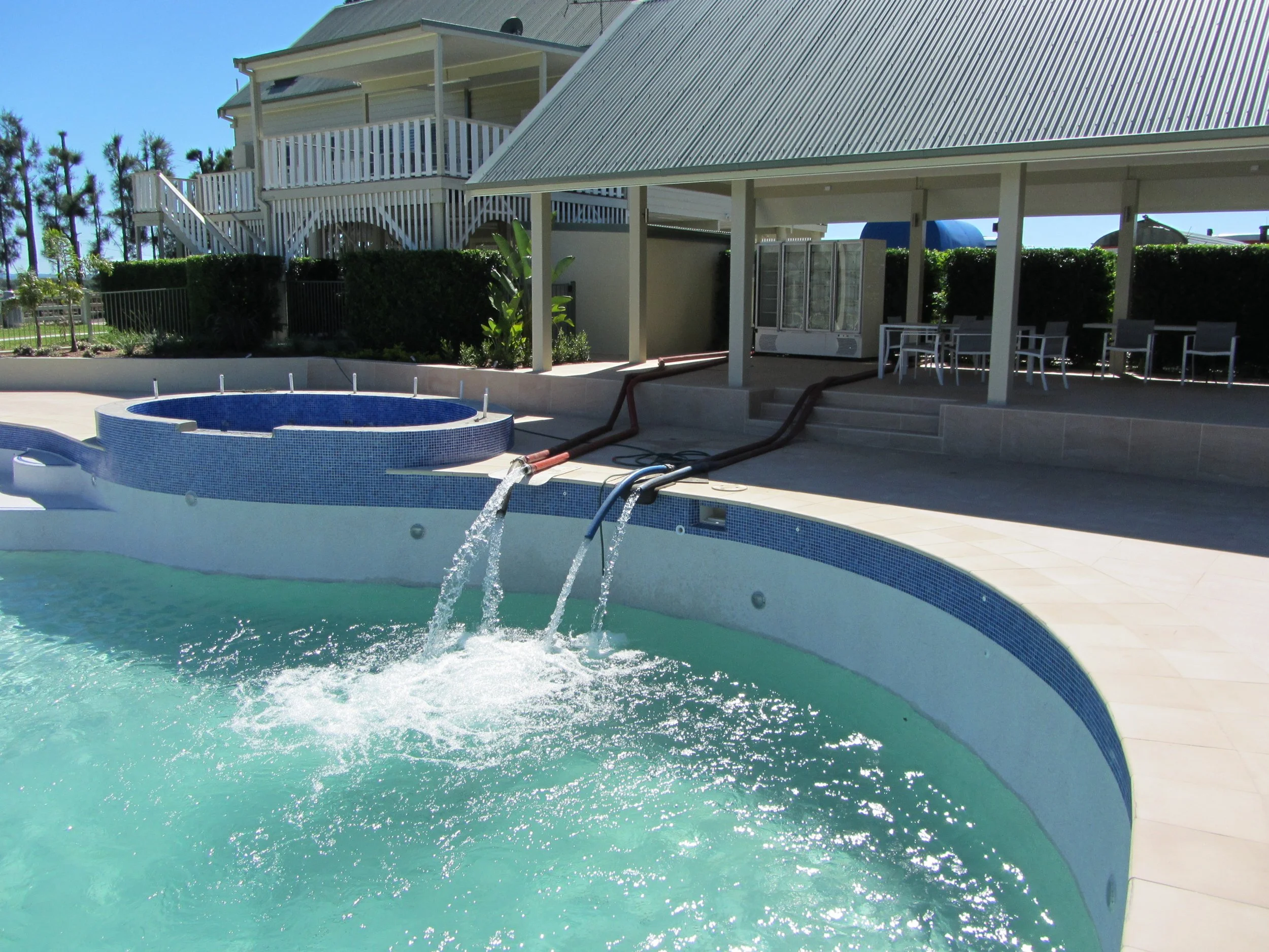 A swimming pool being filled by a water truck