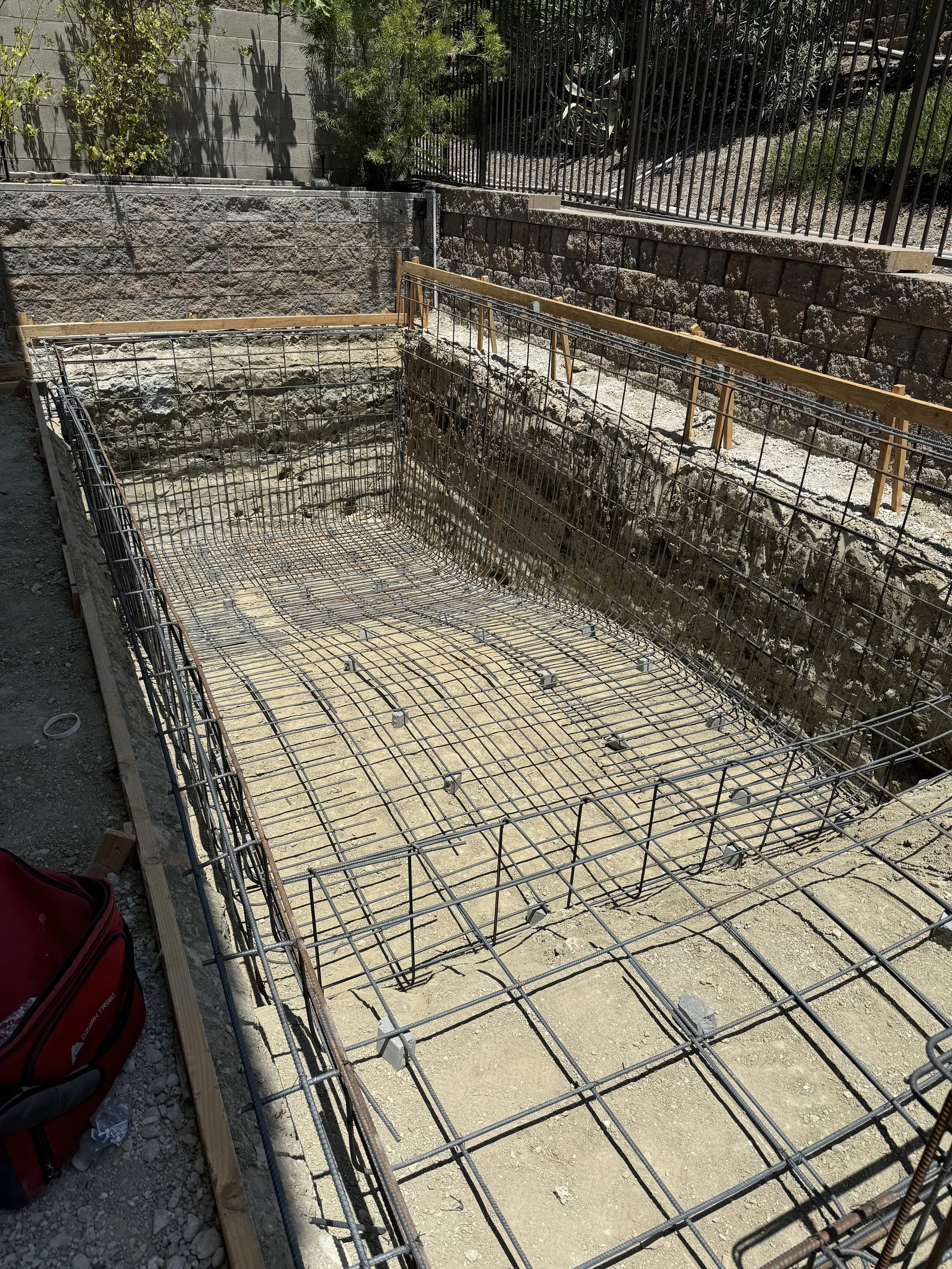 Construction site with rebar and wooden formwork for building foundation.