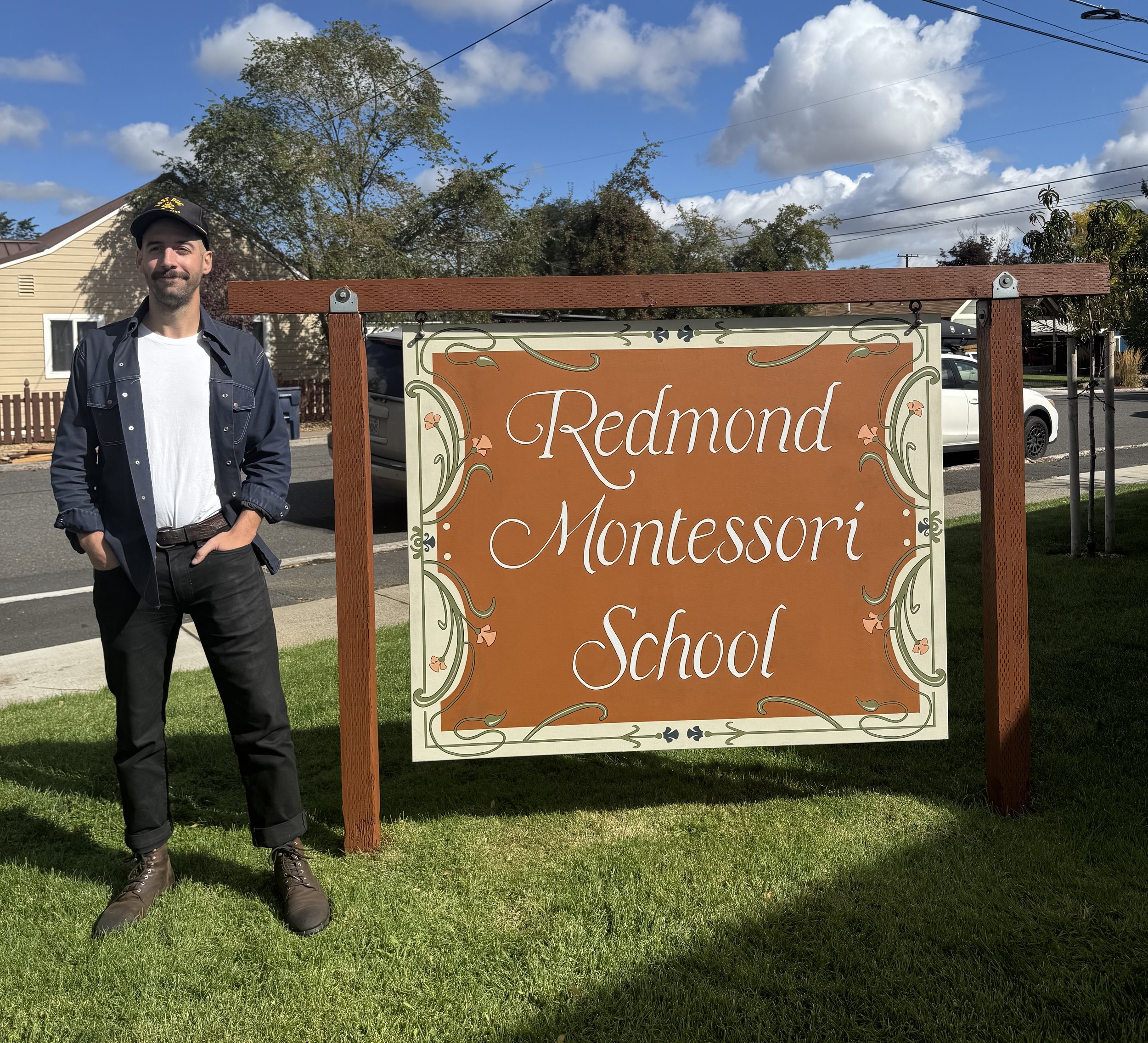 Frank standing next to hand hainted RMS sign