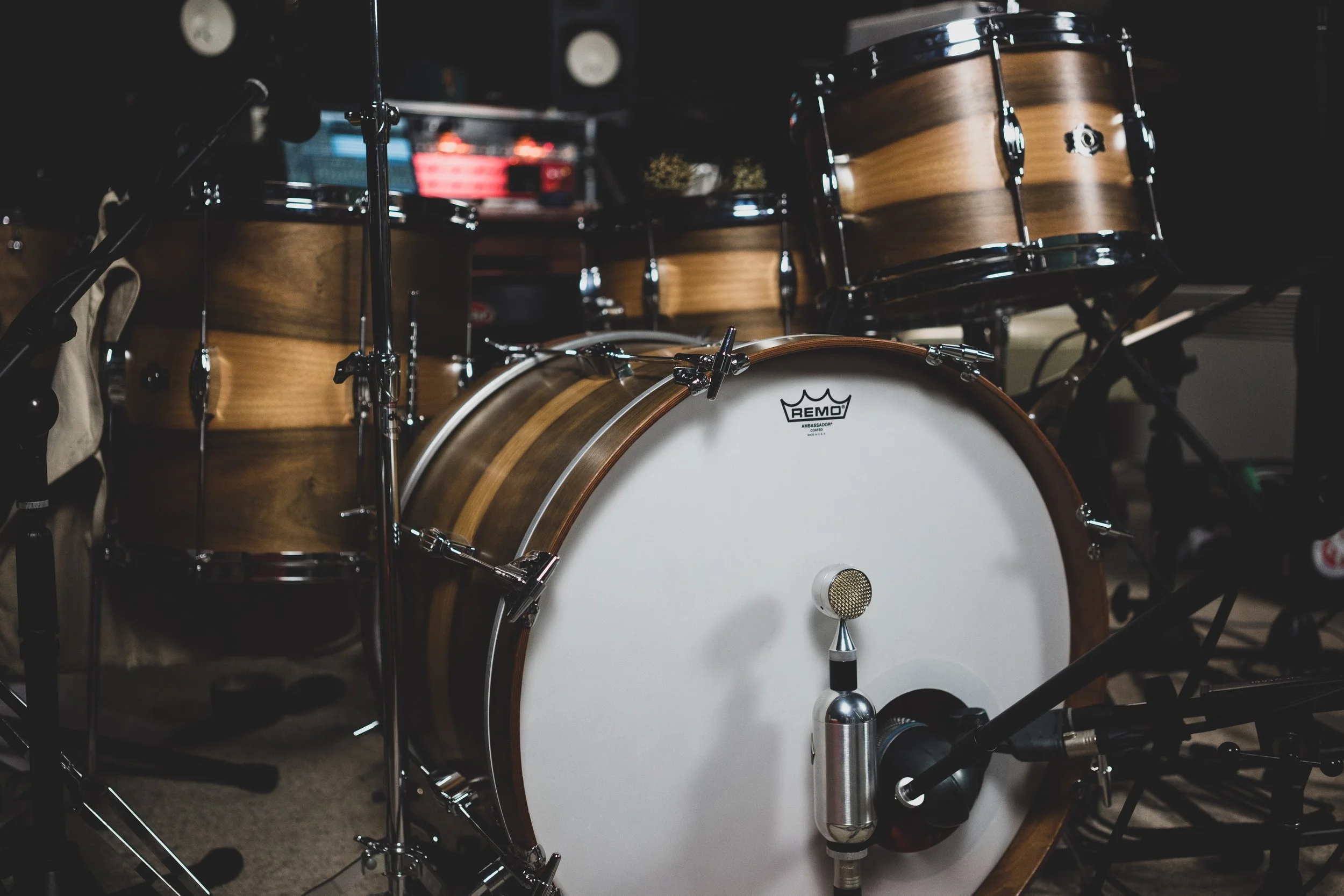 A drum set with a bass drum, tom-toms, and cymbals in a music studio or rehearsal space.