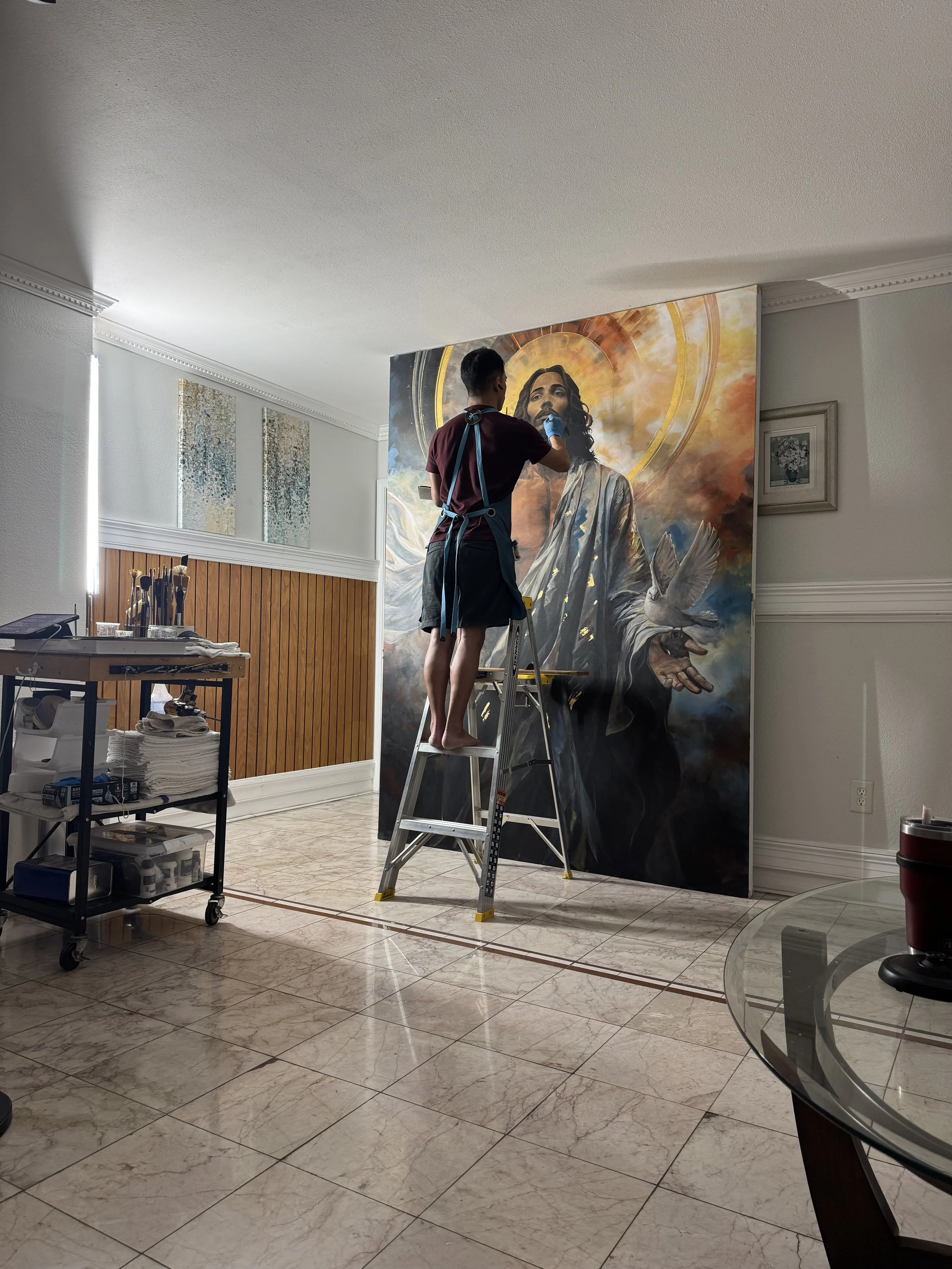 Joe Bertucci working from a stepladder on the Behold painting