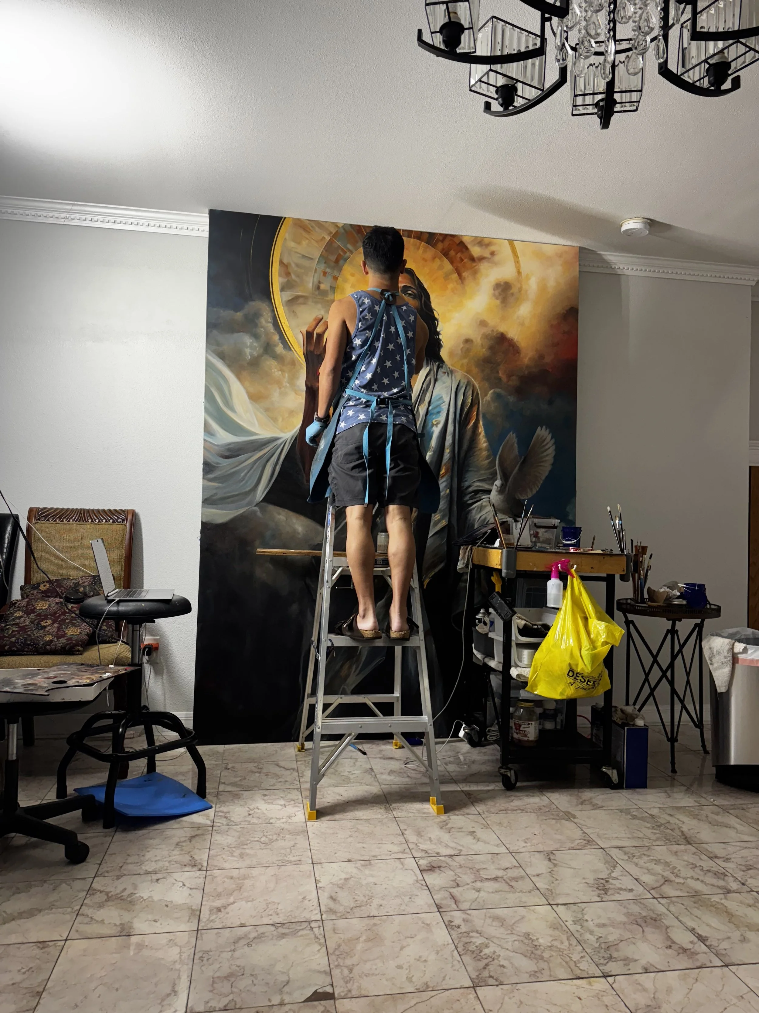 Joe Bertucci working from a ladder on the large Behold painting