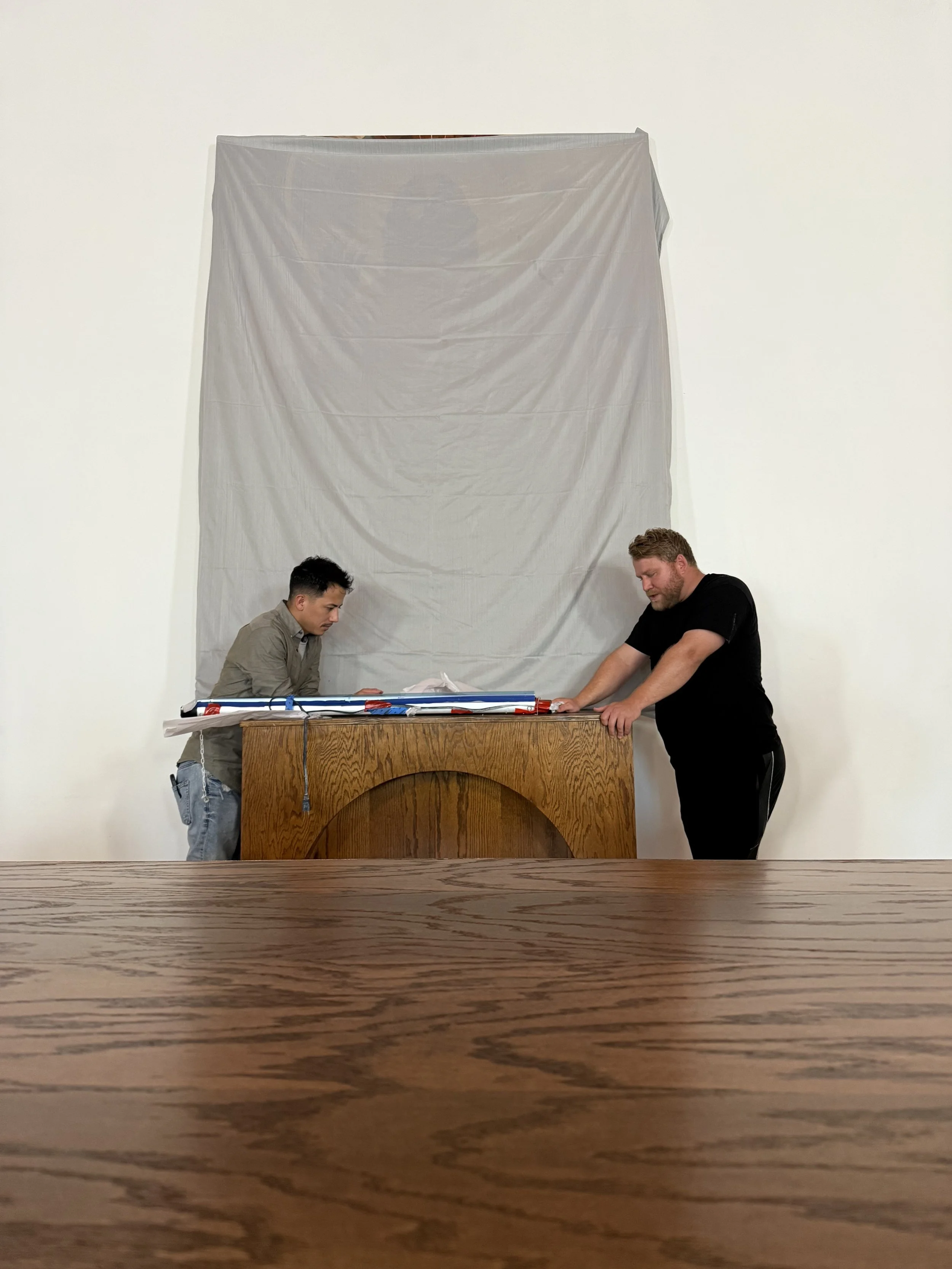 Two people preparing the Behold artwork for installation
