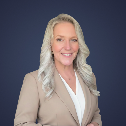 Professional woman with long blonde hair smiling, wearing a beige blazer and white blouse, against a dark blue background.