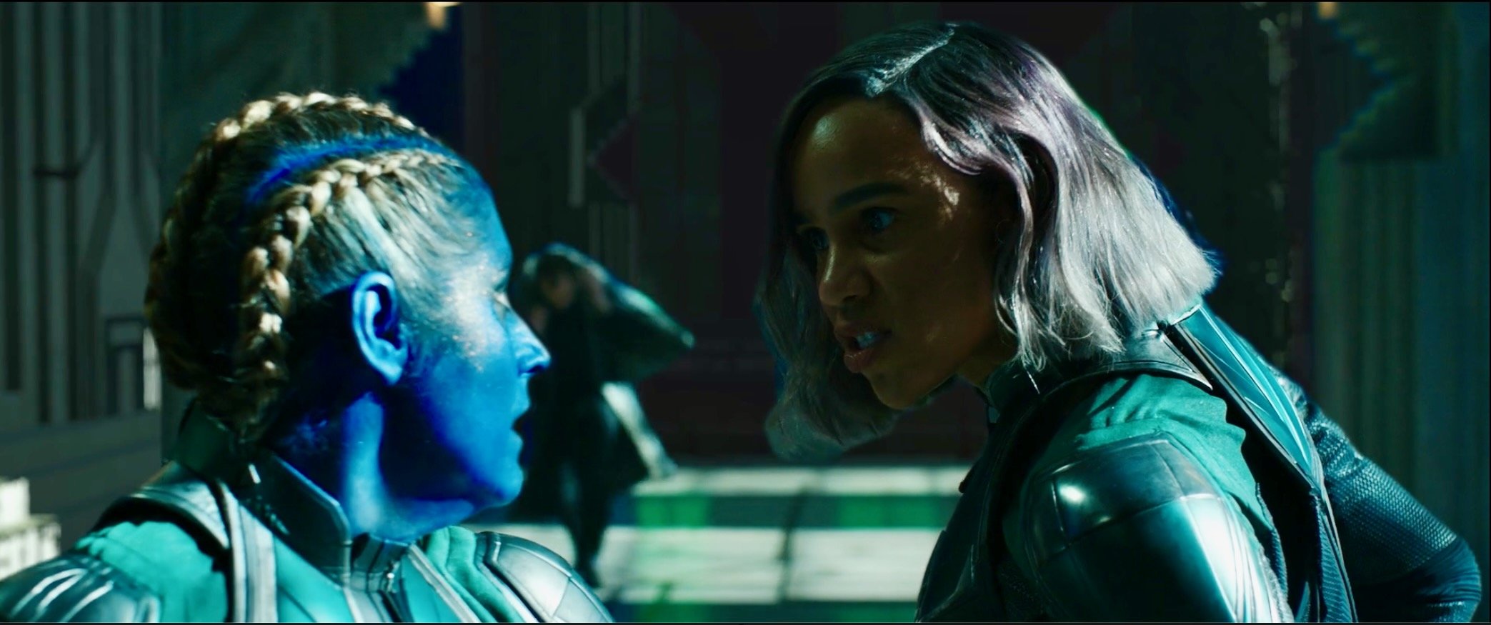 Two women face each other in a tense confrontation on a futuristic set with blue and green lighting.