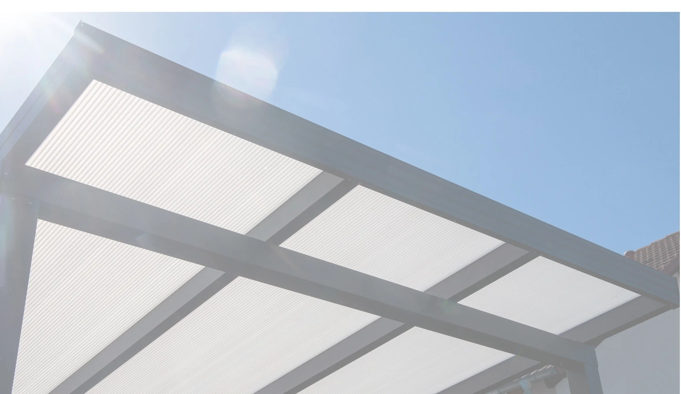 青空と太陽光が反射して輝くカーポート