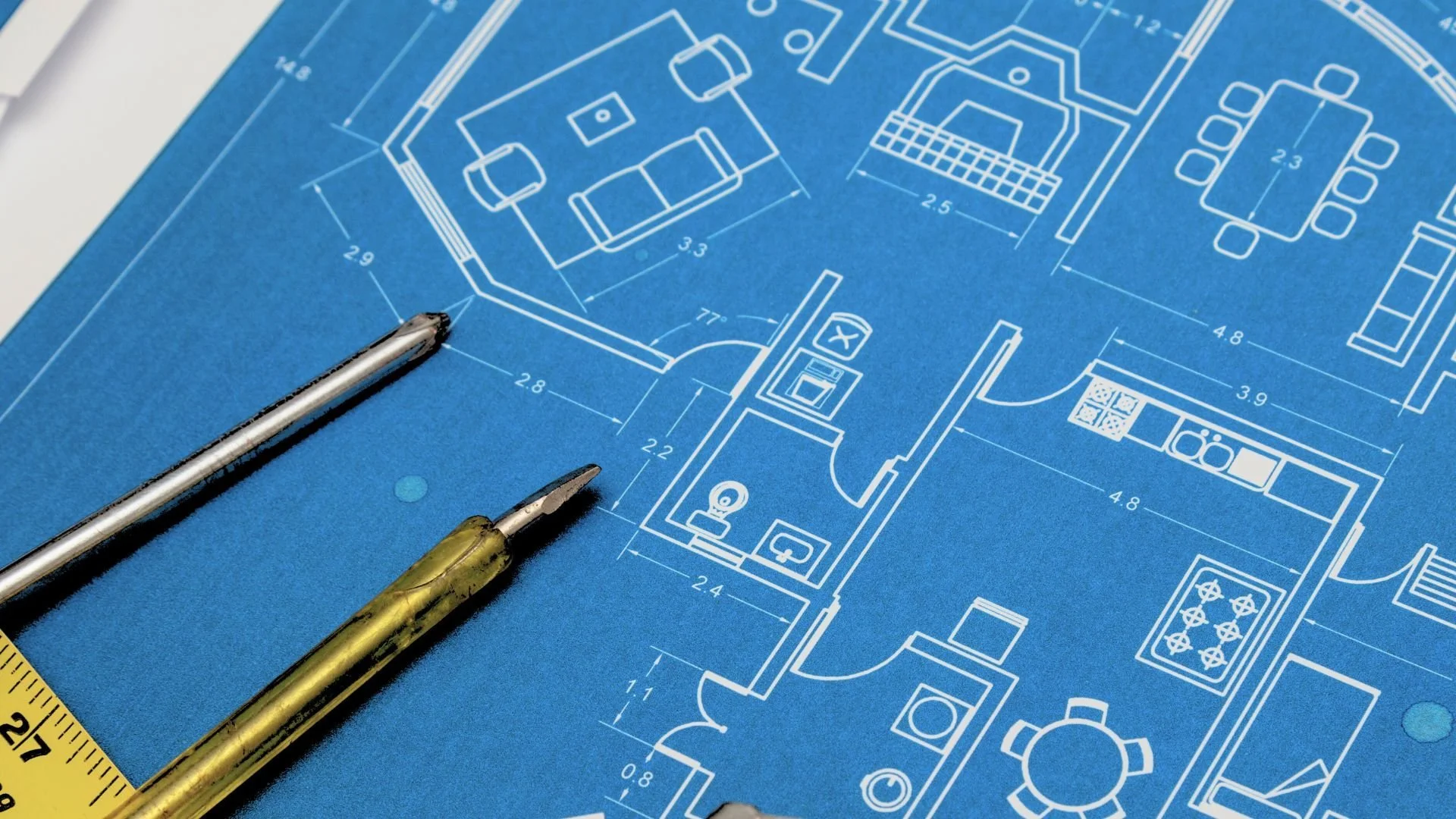 青い設計図に鉛筆と定規が置かれている